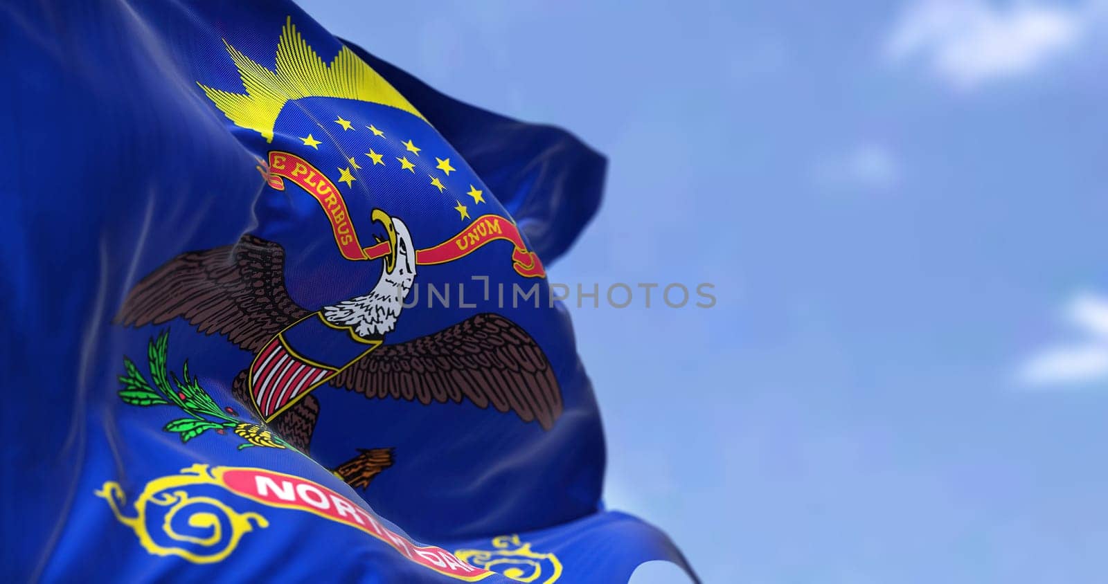 The US state flag of North Dakota waving in the wind. North Dakota is a U.S. state in the Upper Midwest region of the United States. Democracy and independence.