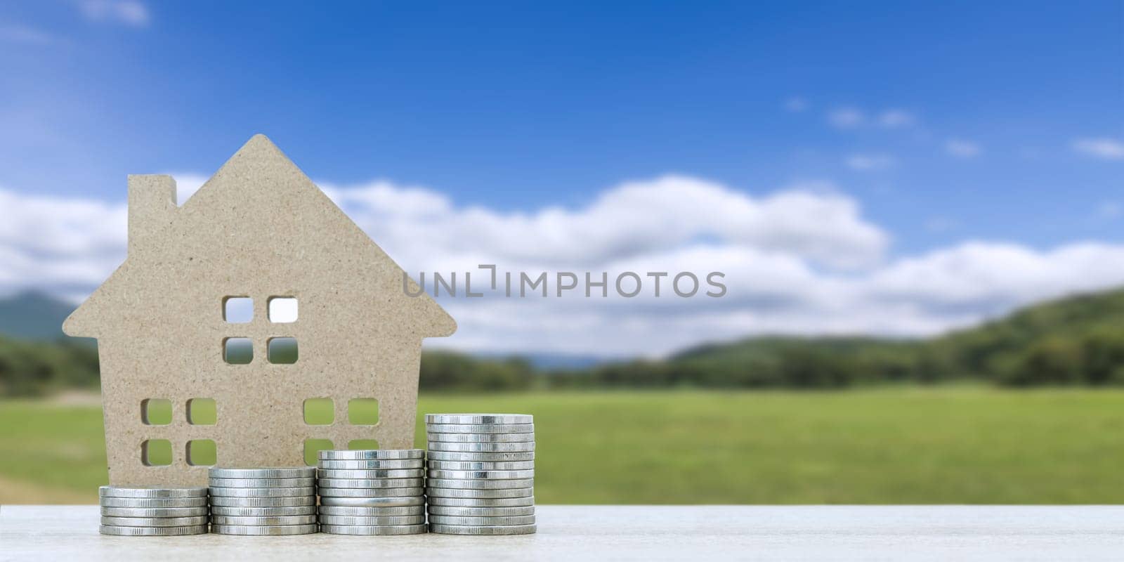 House model and stack of coins with landscape back background for finance and banking concept