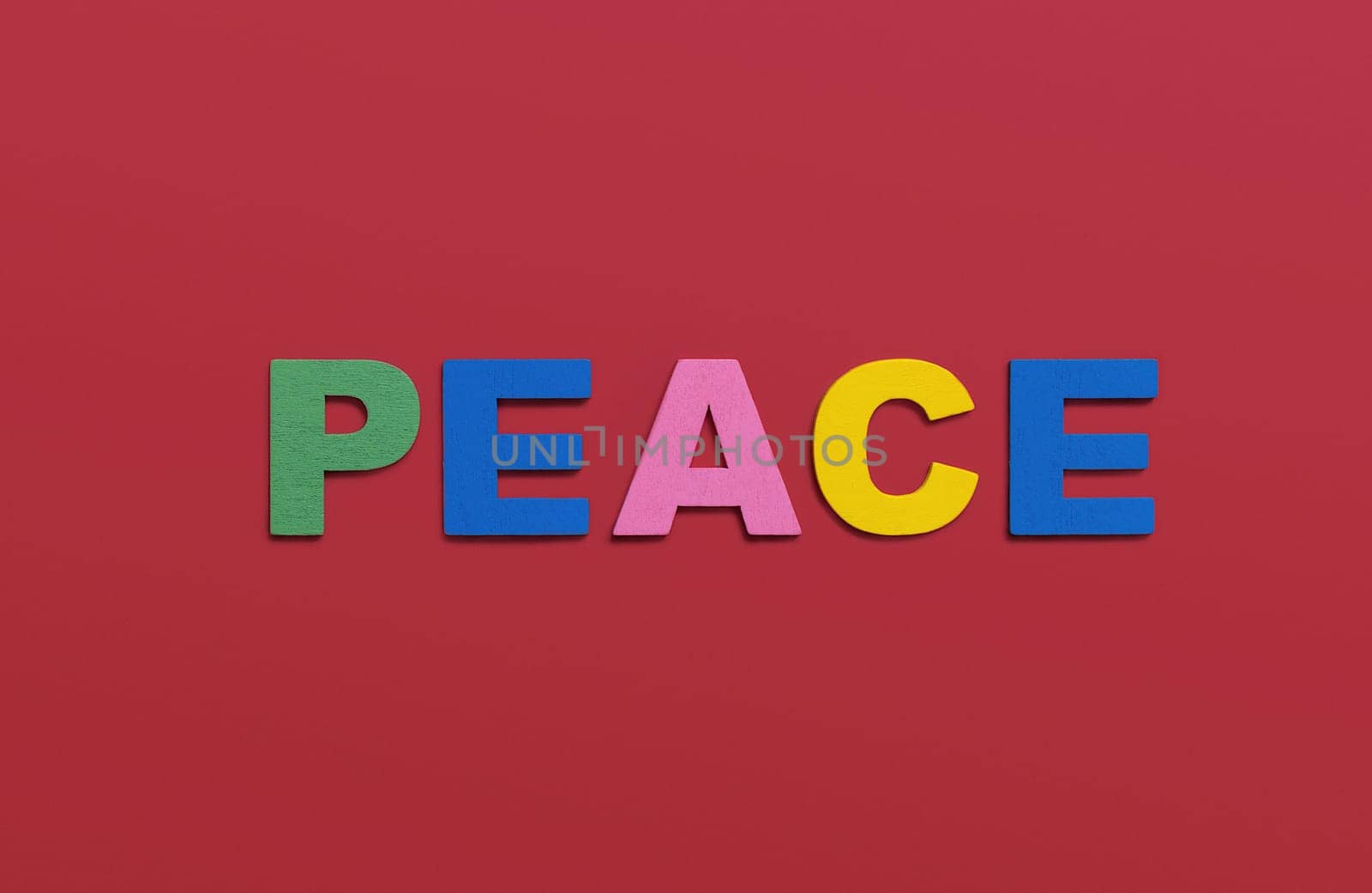 Peace, word written in colorful wooden alphabet letters on red background. The concept of a terrible war destroying country. Top view. Copy space