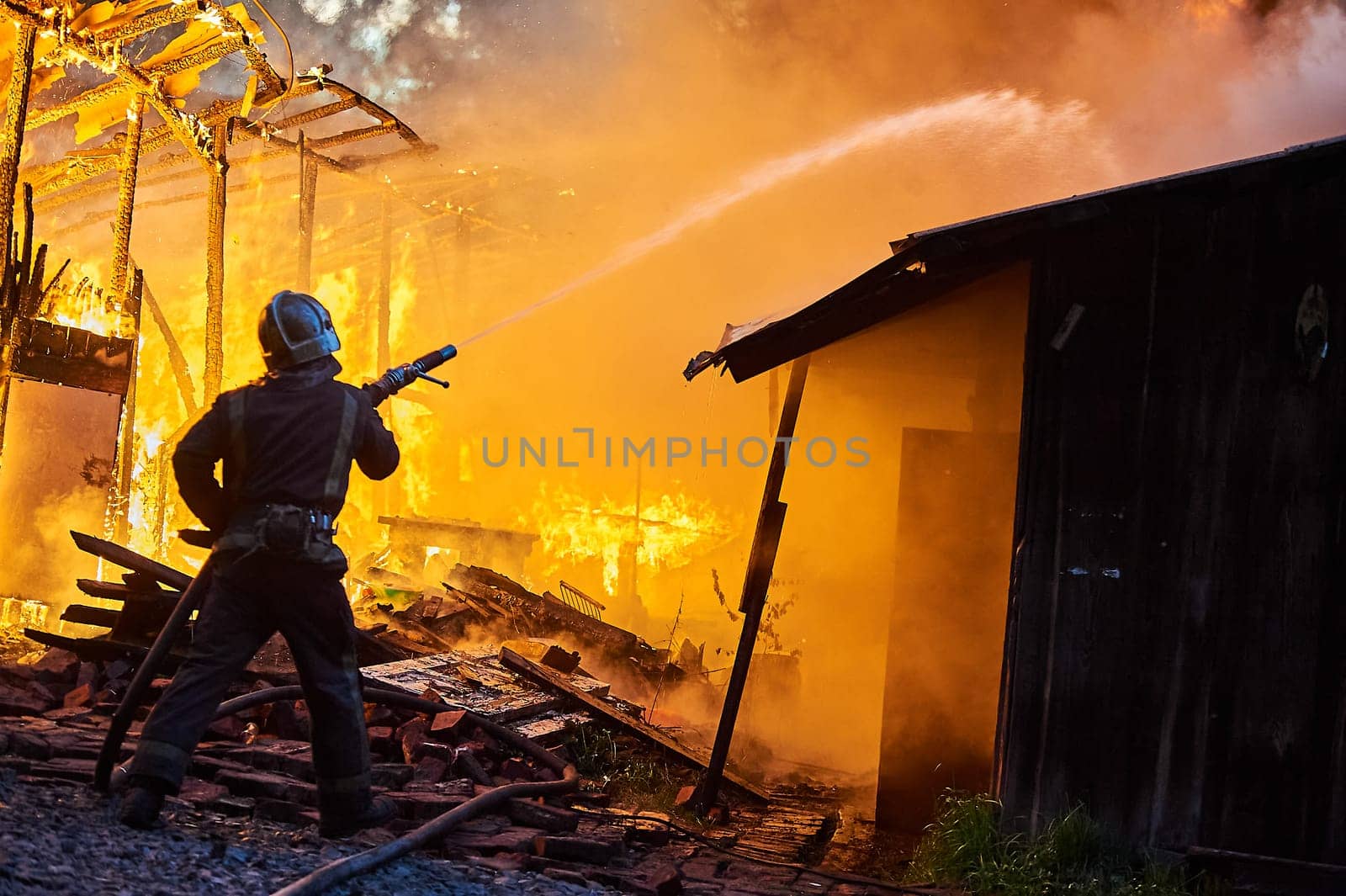 Firefighters extinguish a fire in a farm building. High quality photo