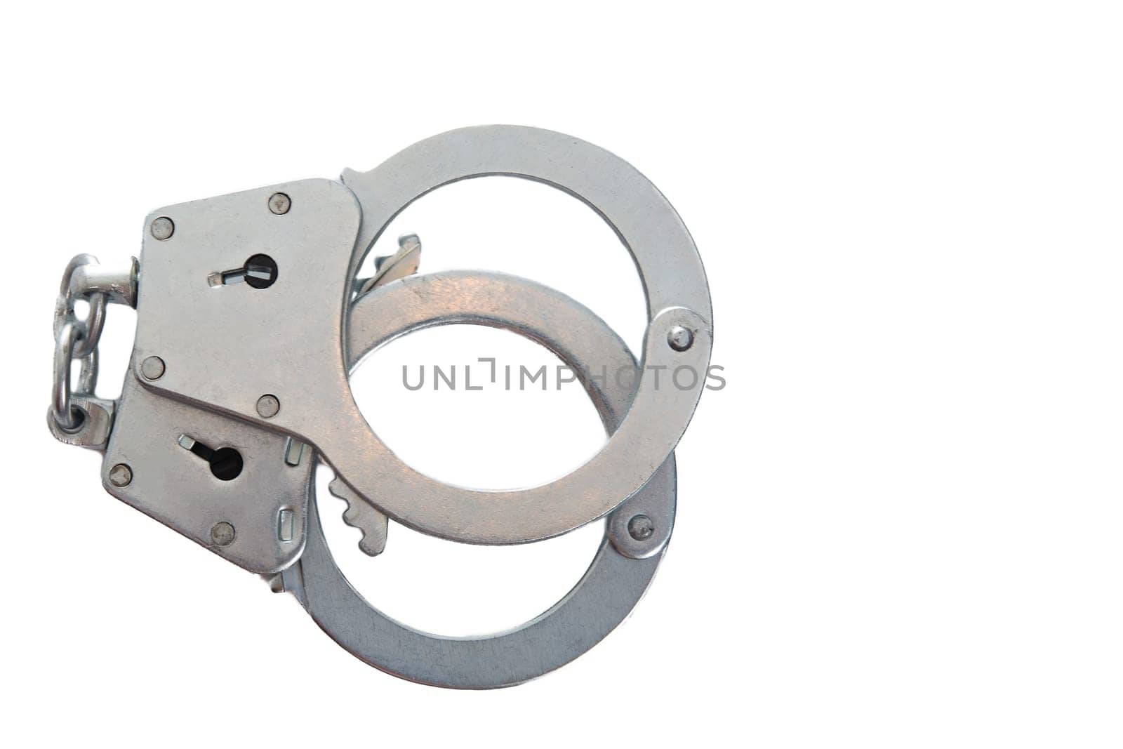 Metal handcuffs on a white isolated background, copy space. High quality photo