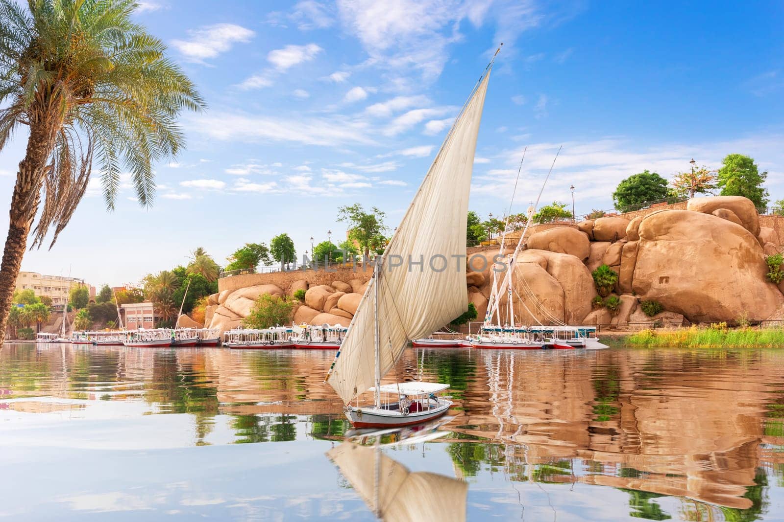 The Nile and Sailboats in front of Traditional buildings of Aswan, Egypt.
