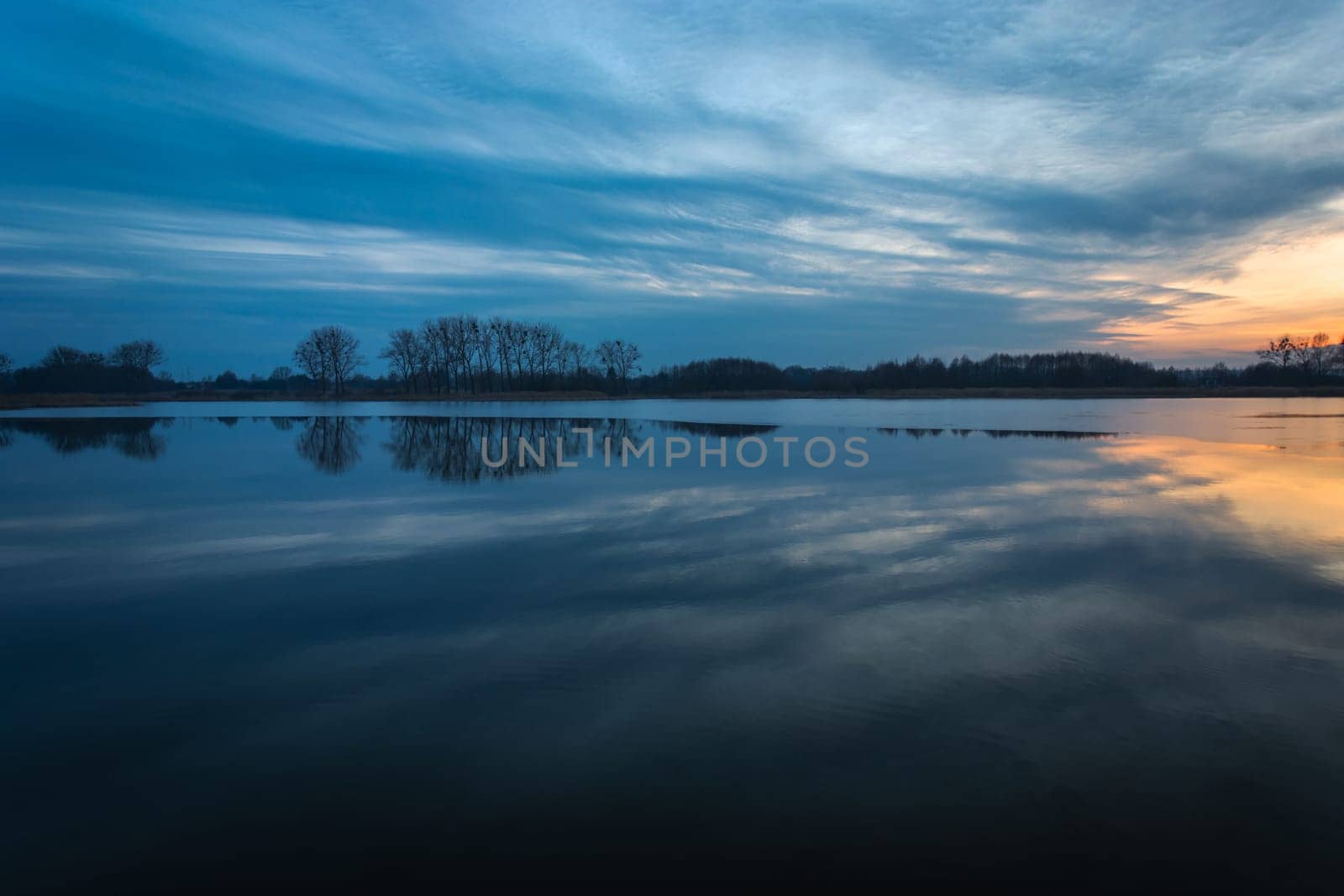 Reflection of the evening clouds in a calm lake, Stankow, Lubelskie, Poland