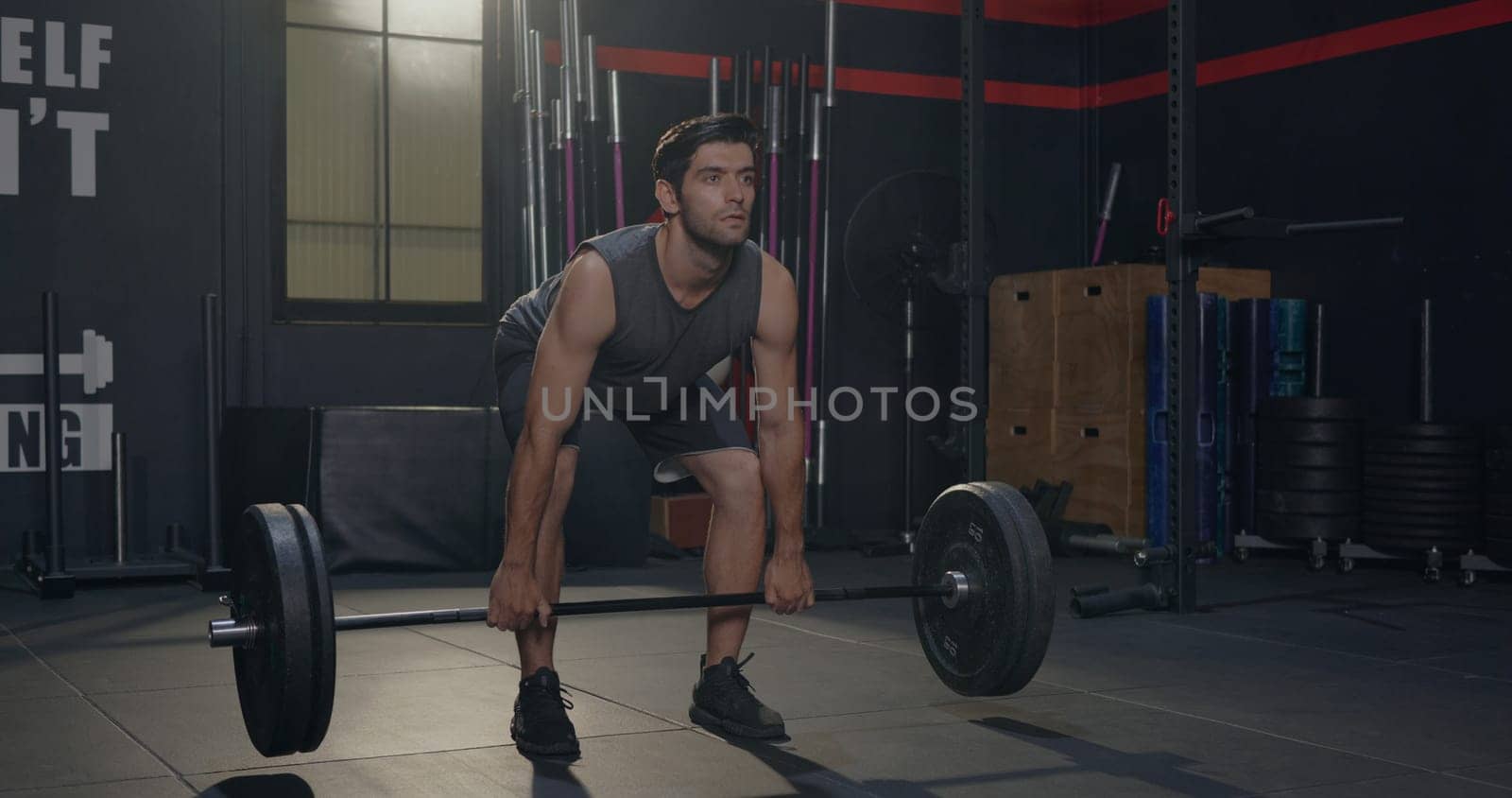 Muscular young Caucasian man exercises working out with lifting weights heavy barbell, Male bodybuilder having workout in gym and fitness club during alone training