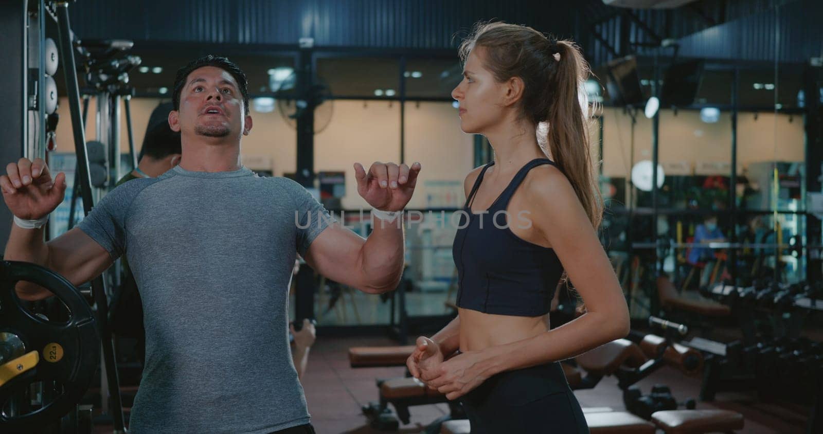 Fitness coach talking explaining training bench press weightlifting with barbell program to woman client, Mature man exercising at fitness gym support under supervision of personal trainer