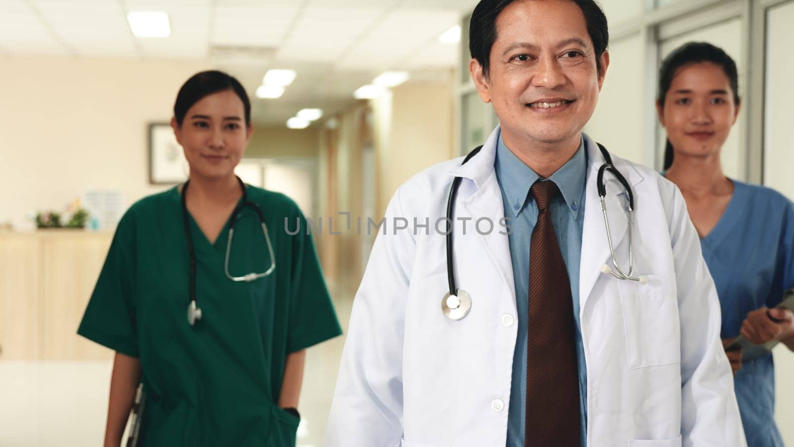 Group of medics busy with clipboard discussing along hospital corridor, Doctor and nurse team with medical report walking down hallway at the hospital