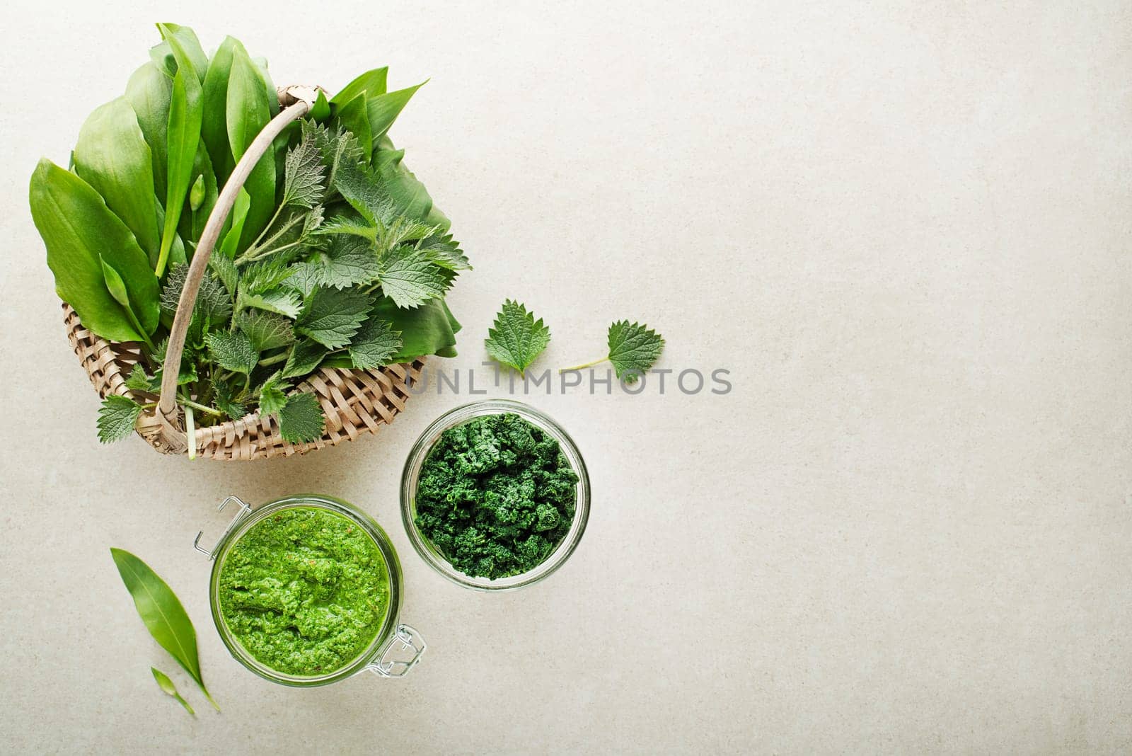 Spring healthy food. Nettle and ramson pesto for healthy meal on grey background