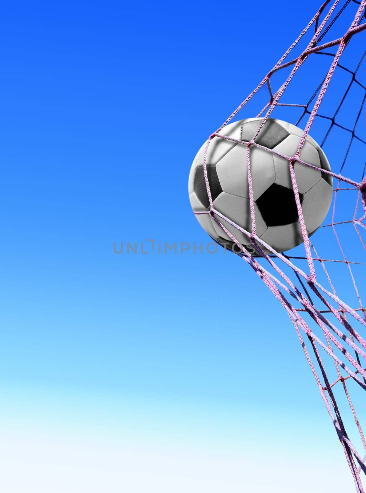 soccer ball in goal net with blue sky