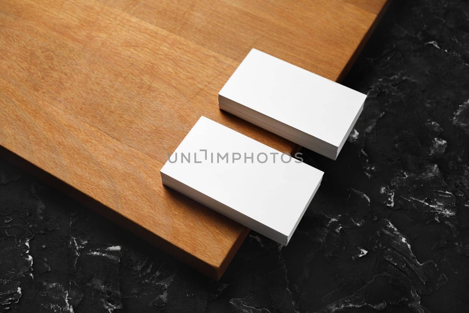 Blank white business cards on wooden board background. Mockup for branding identity. Template for graphic designers portfolios.