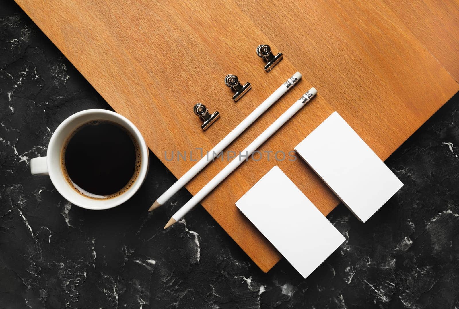 Photo of blank stationery set and coffee cup on wooden board background. Corporate identity template. Flat lay