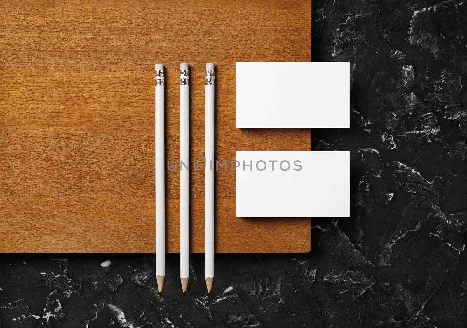 Brand identity mockup. Blank business cards and pencils on wooden board background. Flat lay.