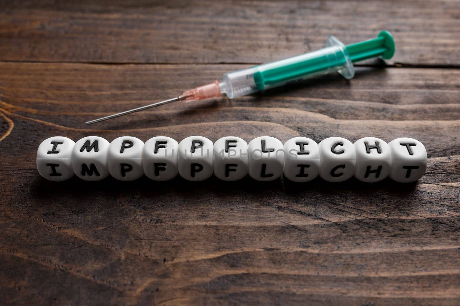 Corona virus Covid-19 vaccine text in German on wooden background