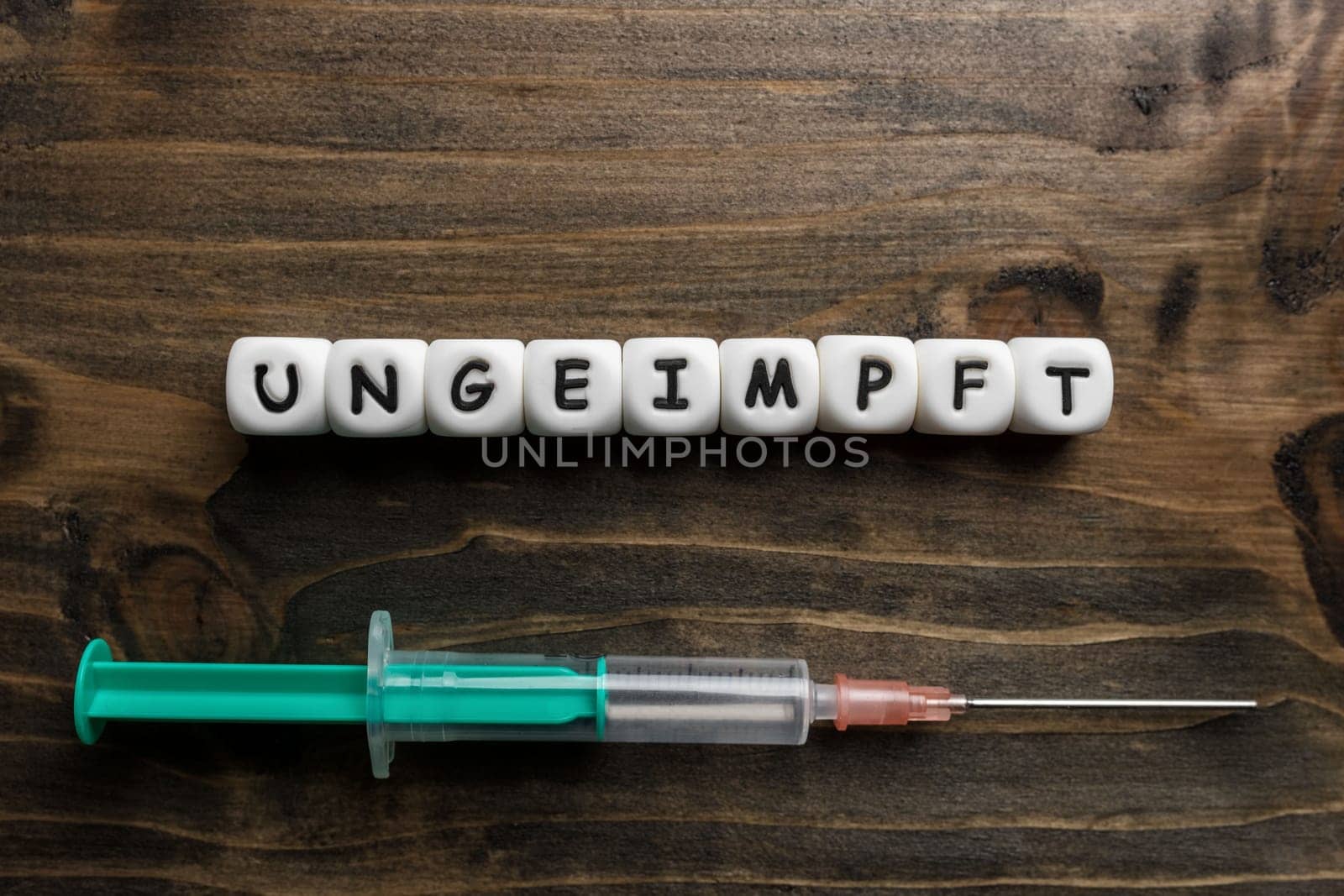 Corona virus Covid-19 vaccine text in German on wooden background