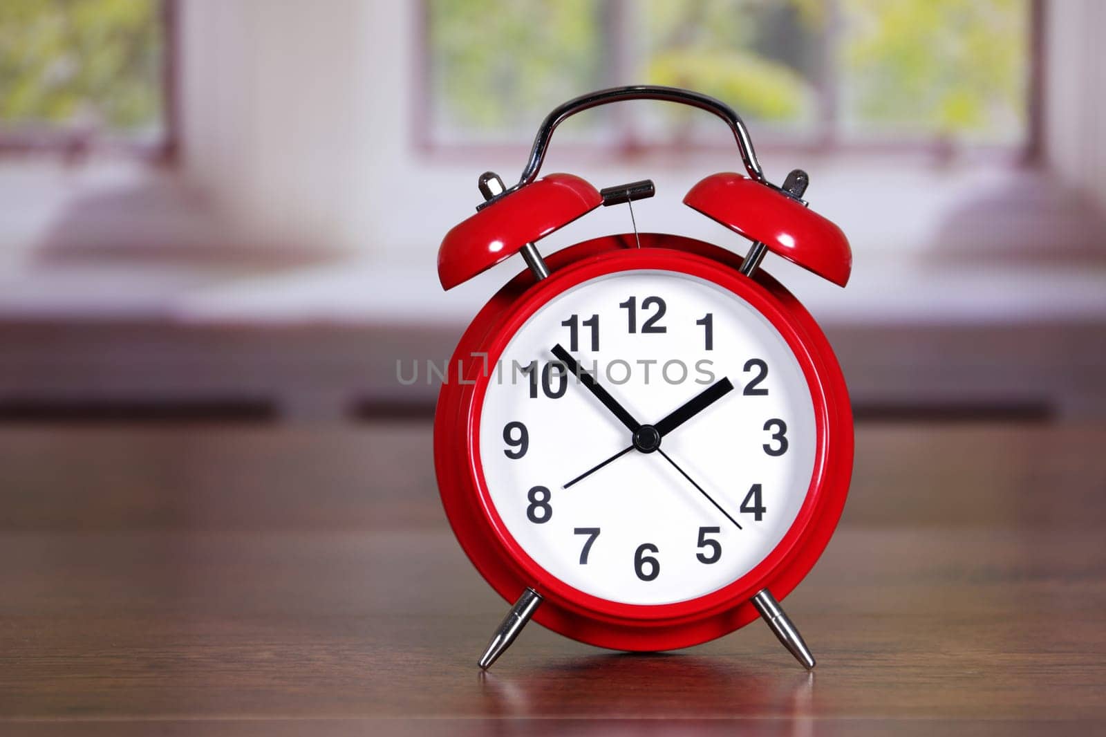 A traditional red alarm clock in room differential focus