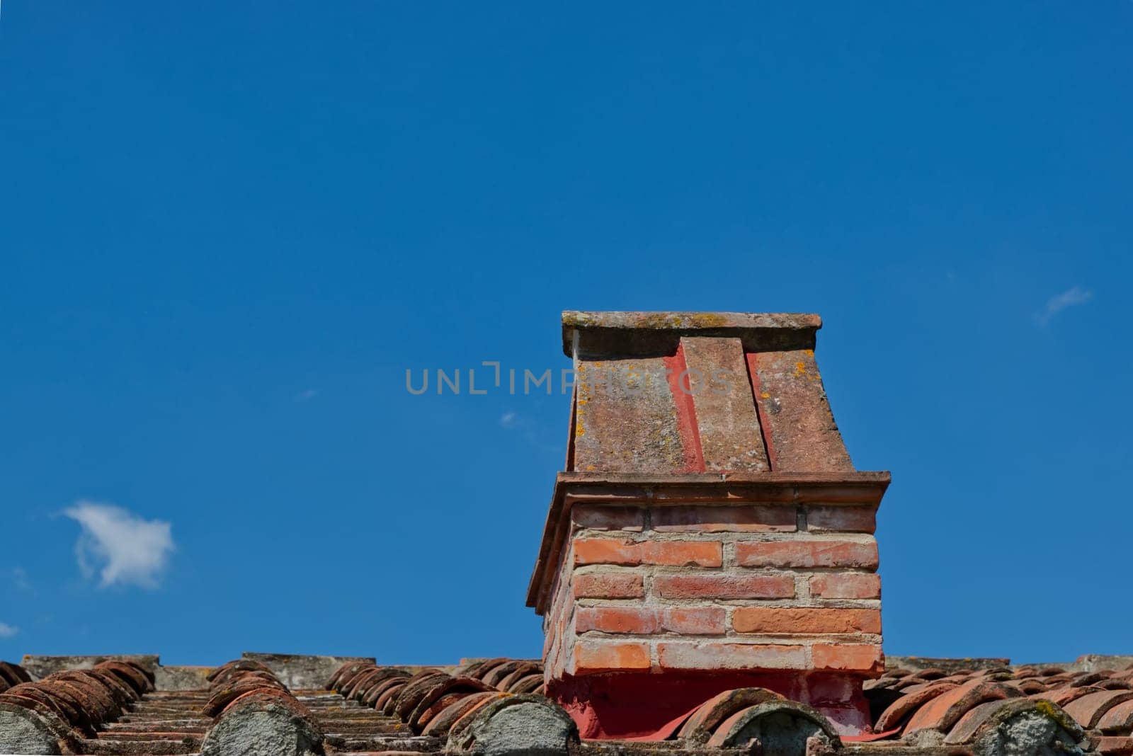 chimney on a tiled roof , blue cloudless sky