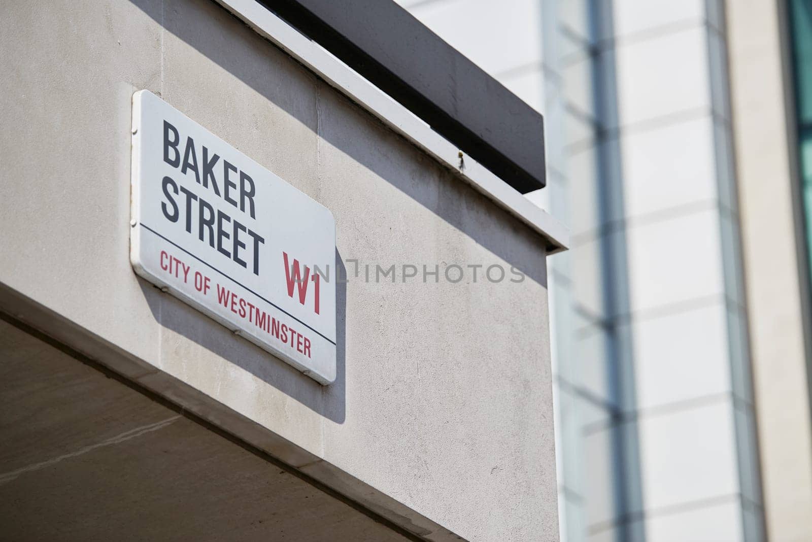 Detail of Baker Street sign on empty white building wall. Lots of copy space.