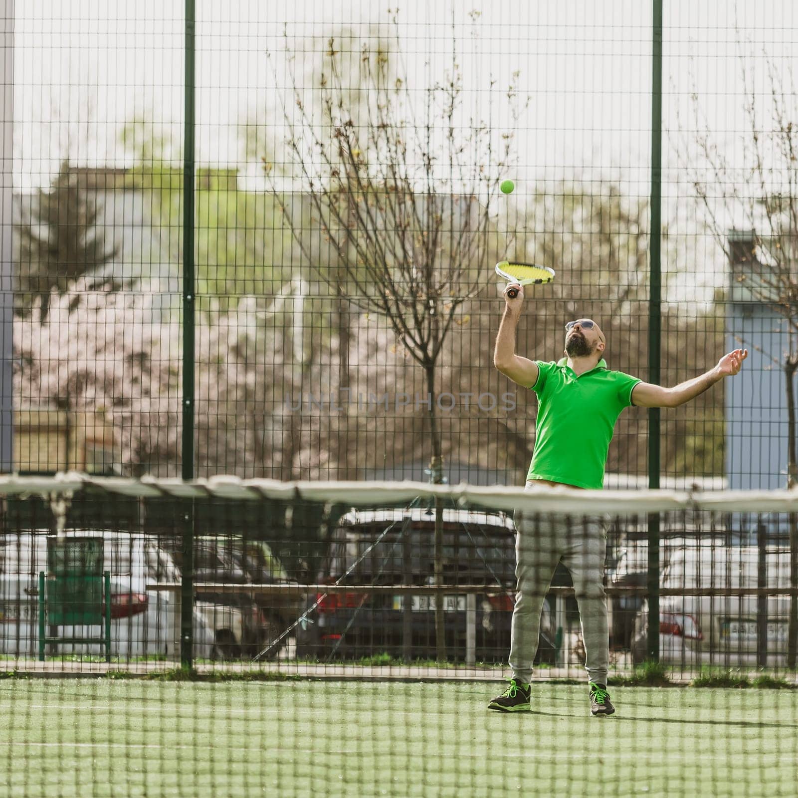 young man play tennis outdoor on tennis field at early morning
