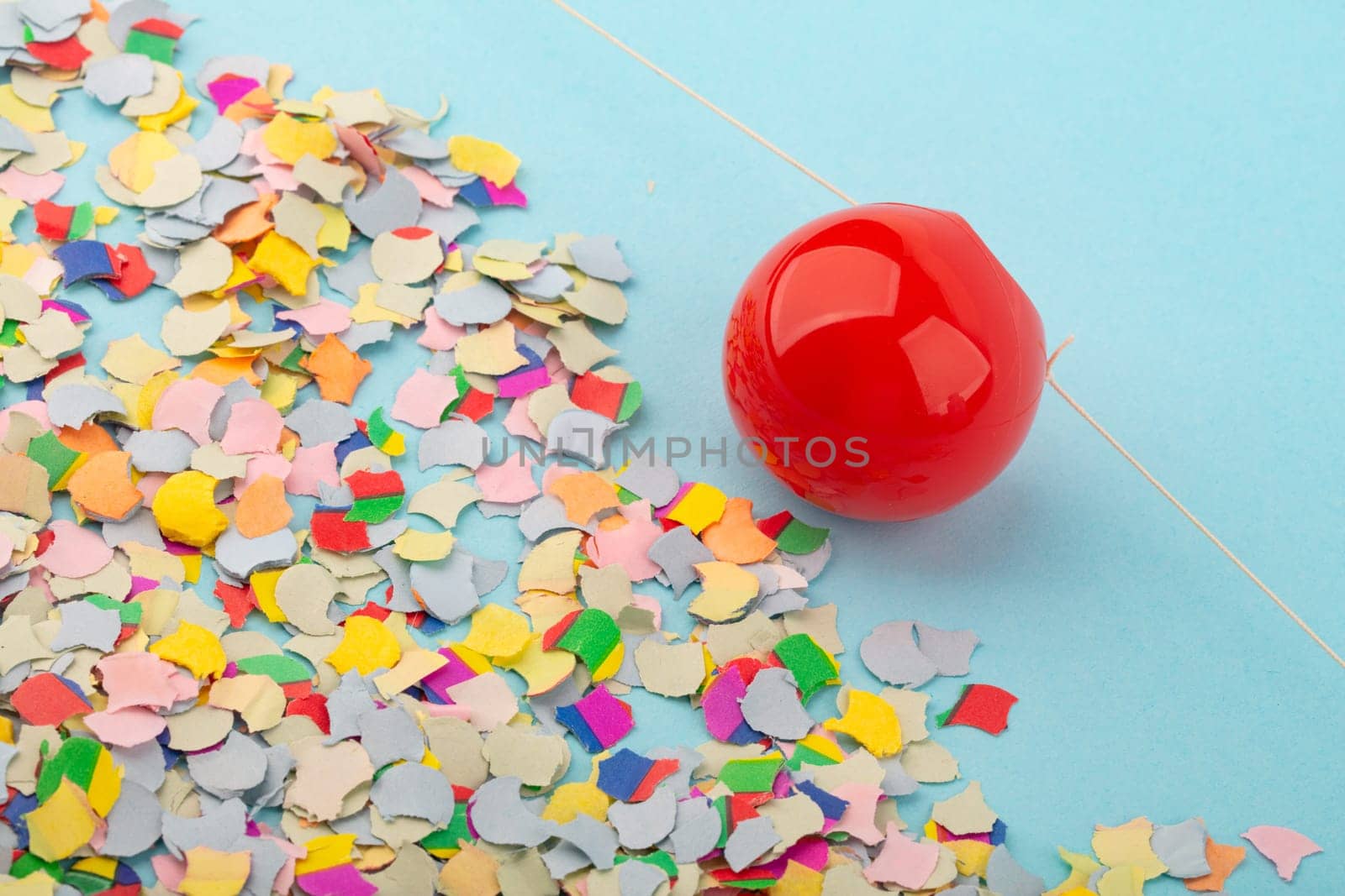 Red Nose with confetti over light blue background.