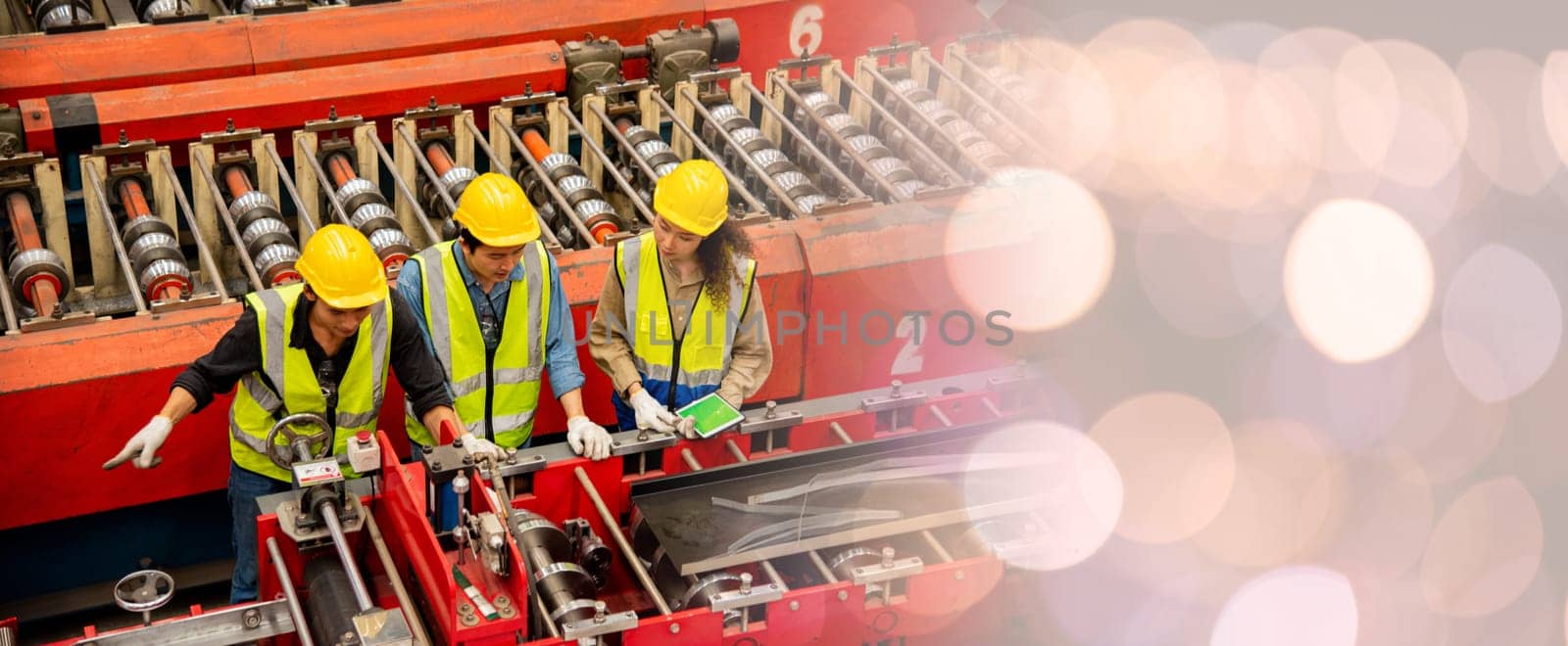 Engineer and operator wearing a safety suit maintaining machine in industrial metal sheet factory, team worker walk teaching help friend operate control heavy machine in factory with many equipment