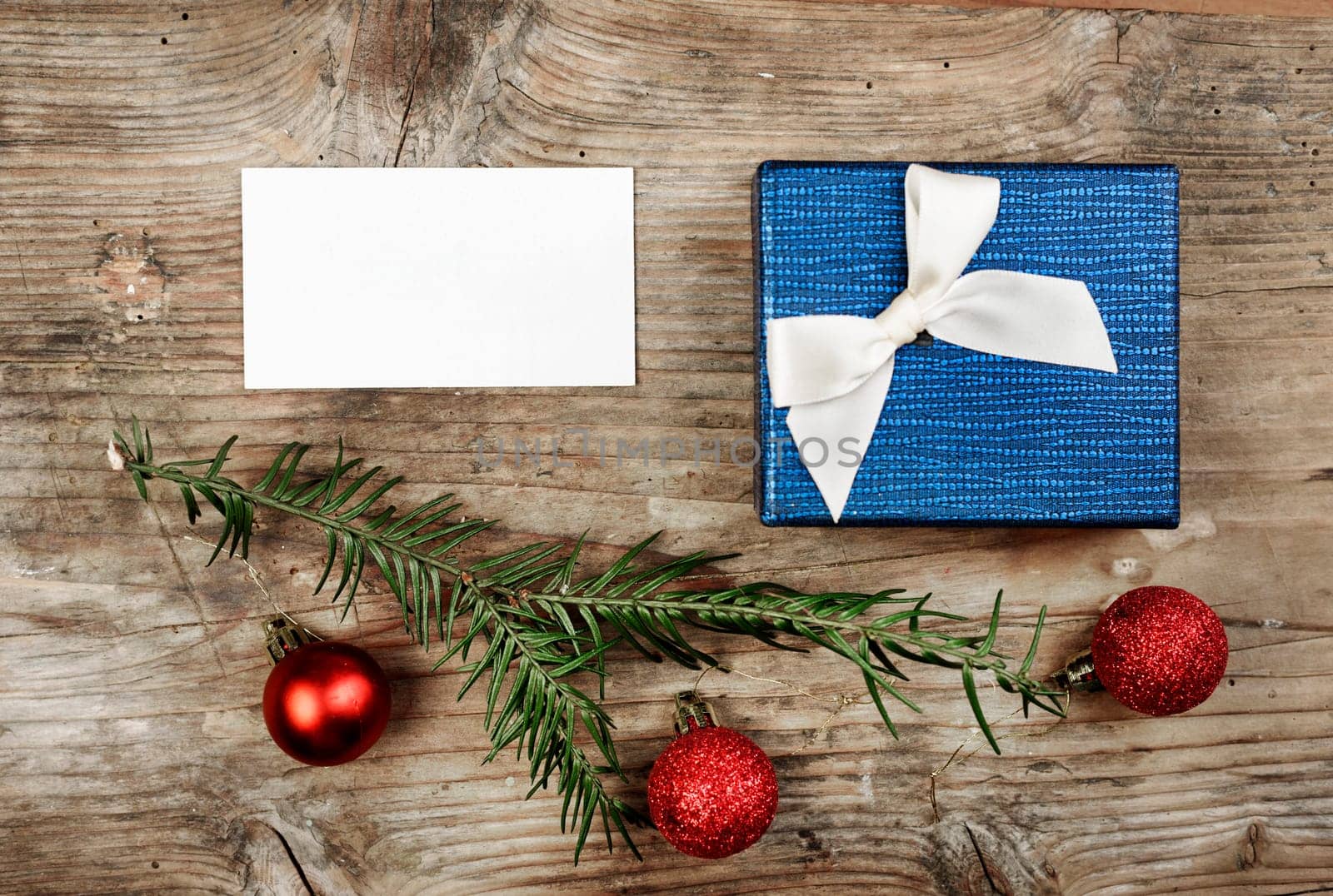 Christmas present and empty card on wooden table.