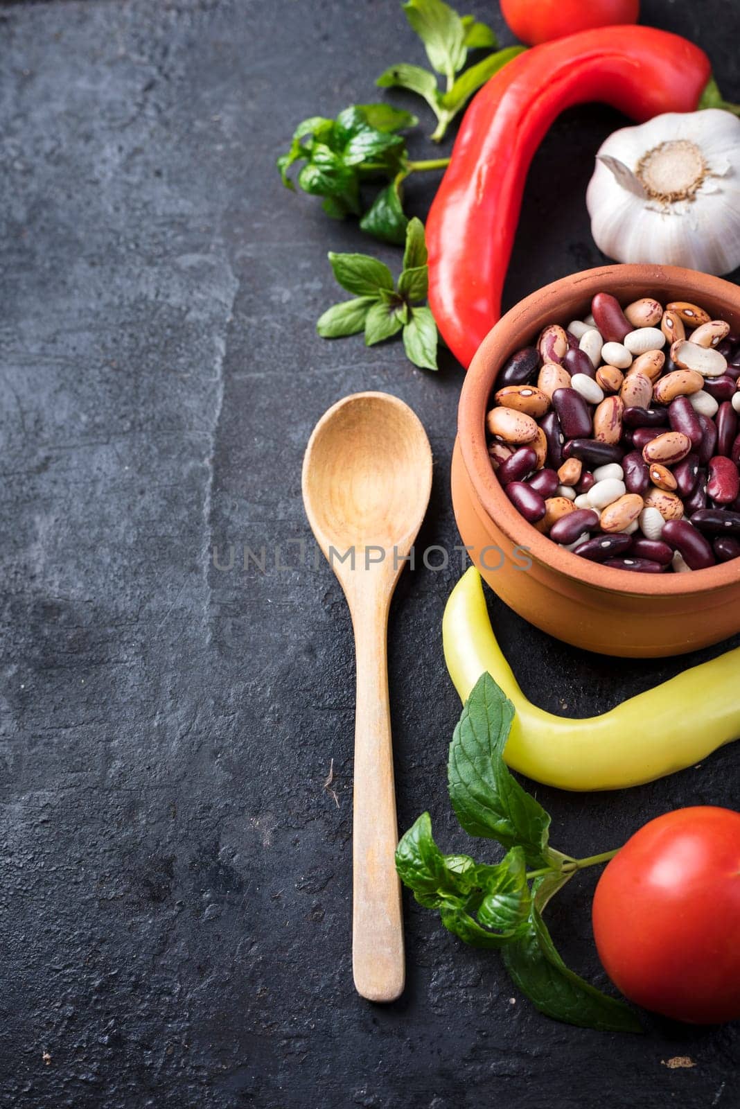 Beans, paprika, tomato and herbs on black rustic background. Recipe for traditional baked beans.