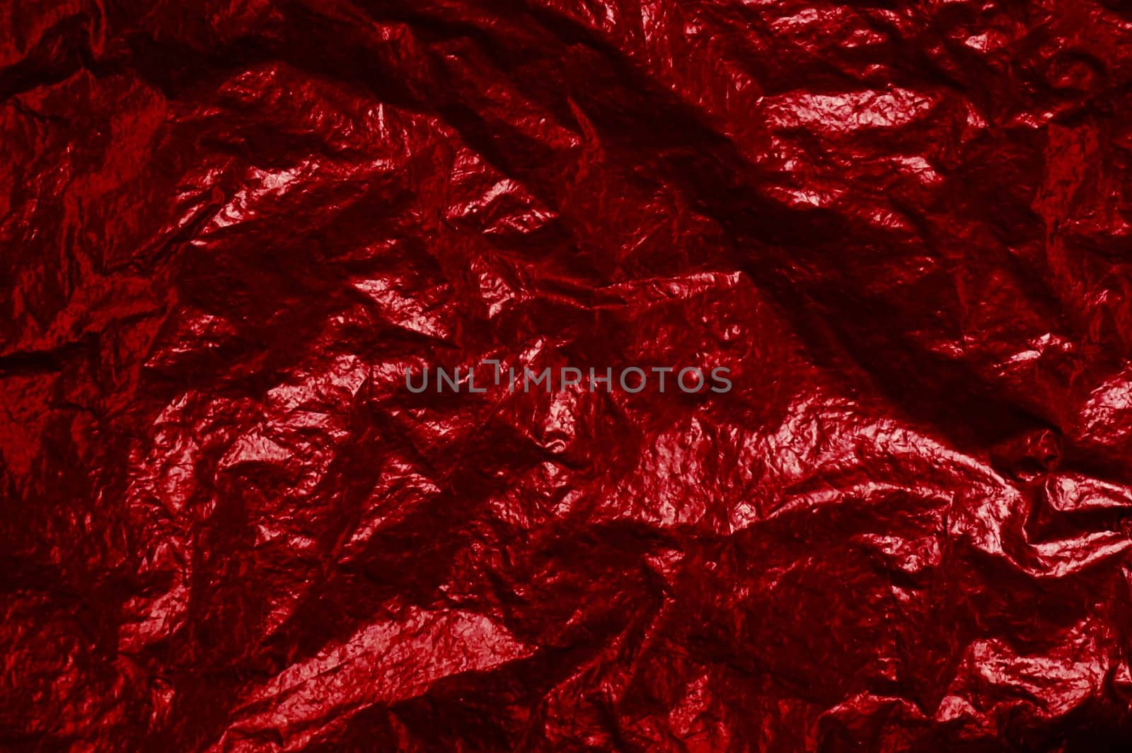 Background texture of red shiny foil with light reflection