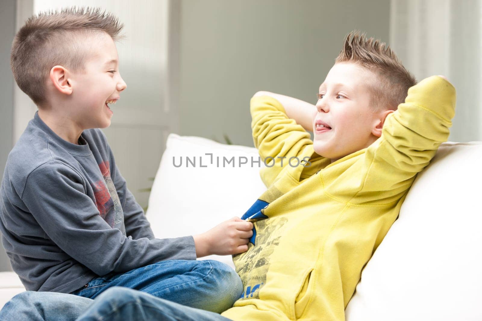 little brothers one in front of the other one smiling and laughing