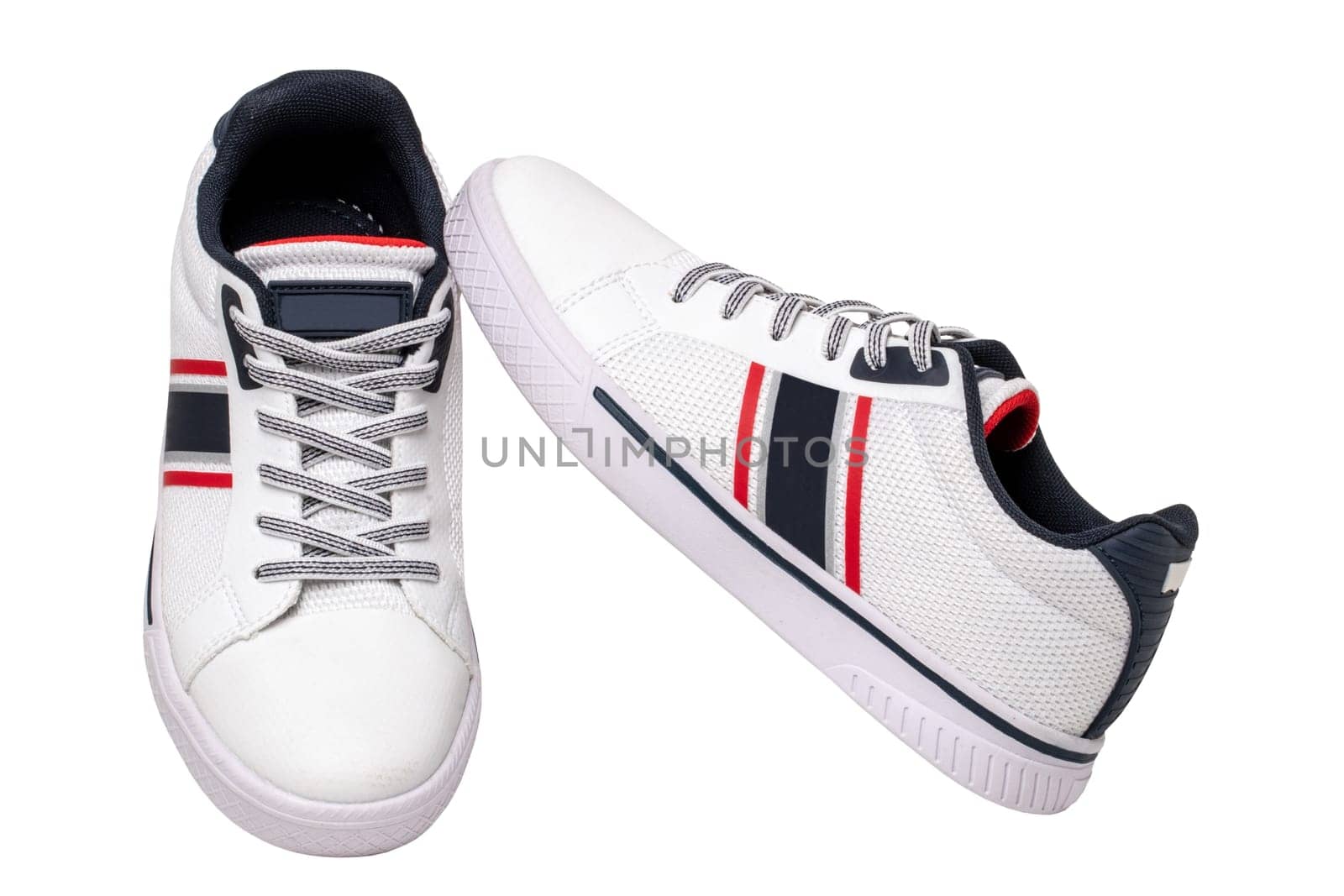 White sneakers isolated. Close-up of a pair white elegant stylish leather sport shoes isolated on a white background. Clipping path. Kids shoe fashion. Modern design footwear for workout. Macro.