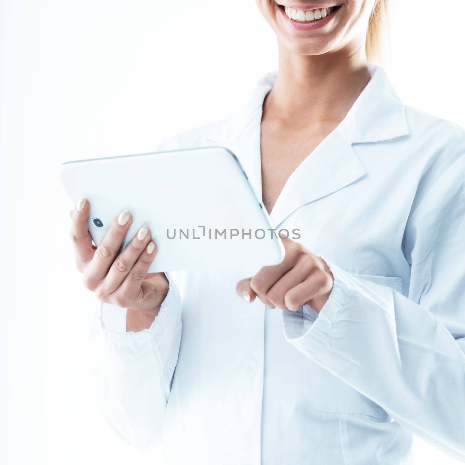 smiling doctor holding a digital tablet and tapping with her index finger