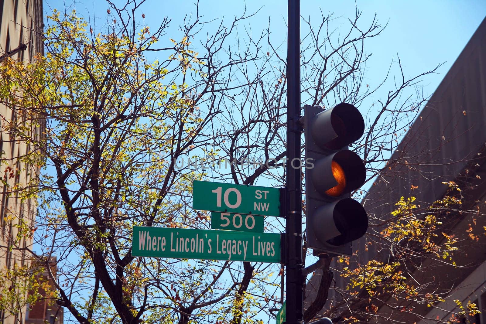 Green 10 Street North West historic sign in downtown Washington D.C. with yellow traffic light, Where Lincoln's Legacy Lives