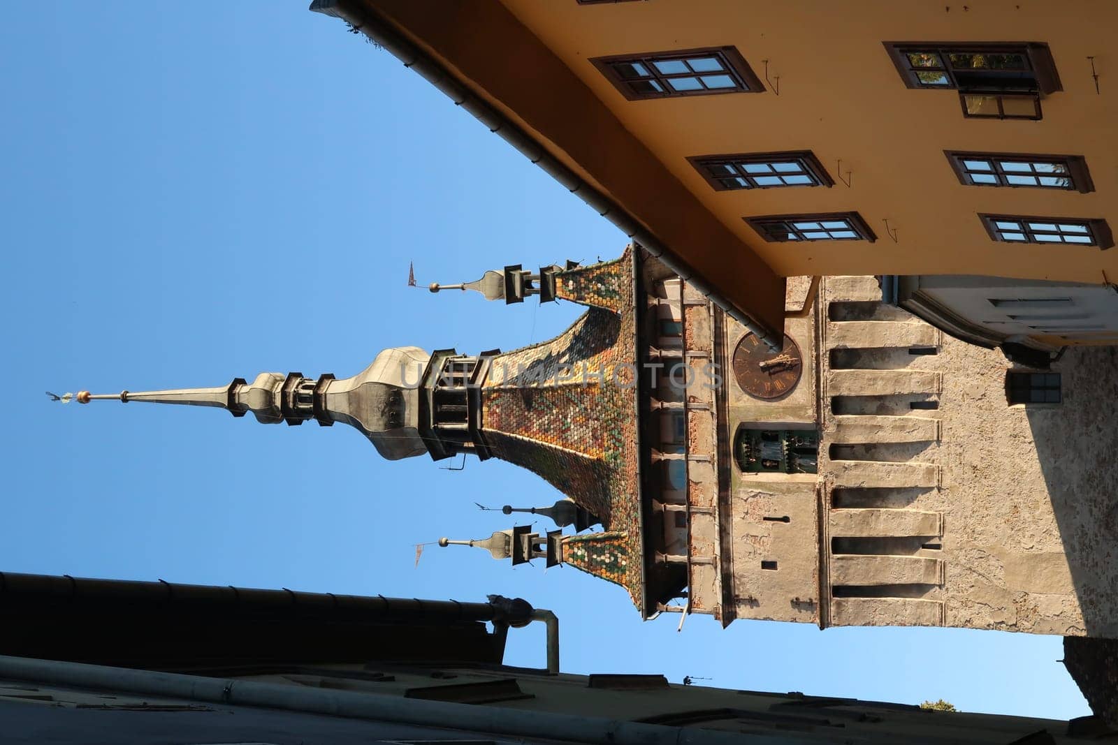 Glimpse on Sighisoaras famous Clock Tower from inside of the Citadel at Golden hour, Romania 2021