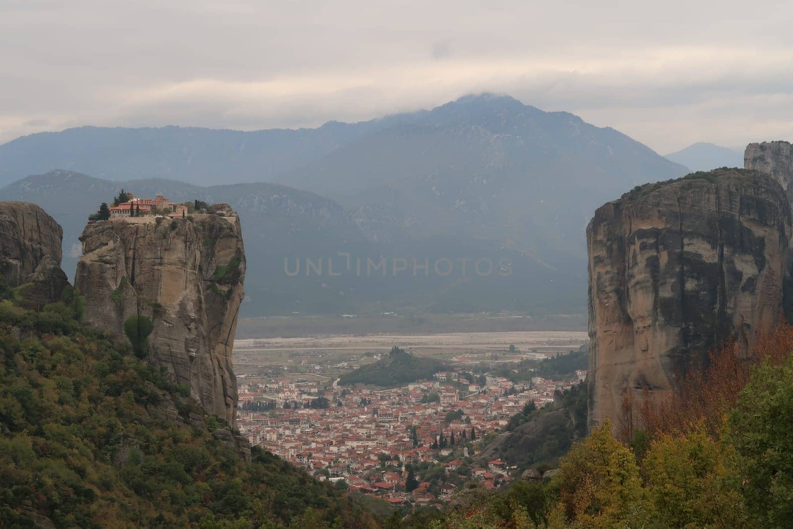 Impressive view between the rocks onto Kalambaka, the Monastery of the Holy Trinity in the front, Meteora, Greece 2021