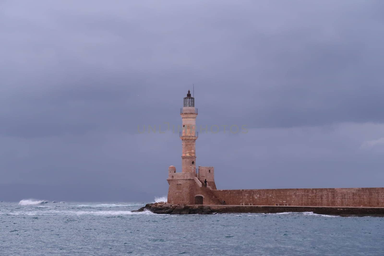 Chania's lighthouse resisting the rough sea in fall, Crete, Greece 2021