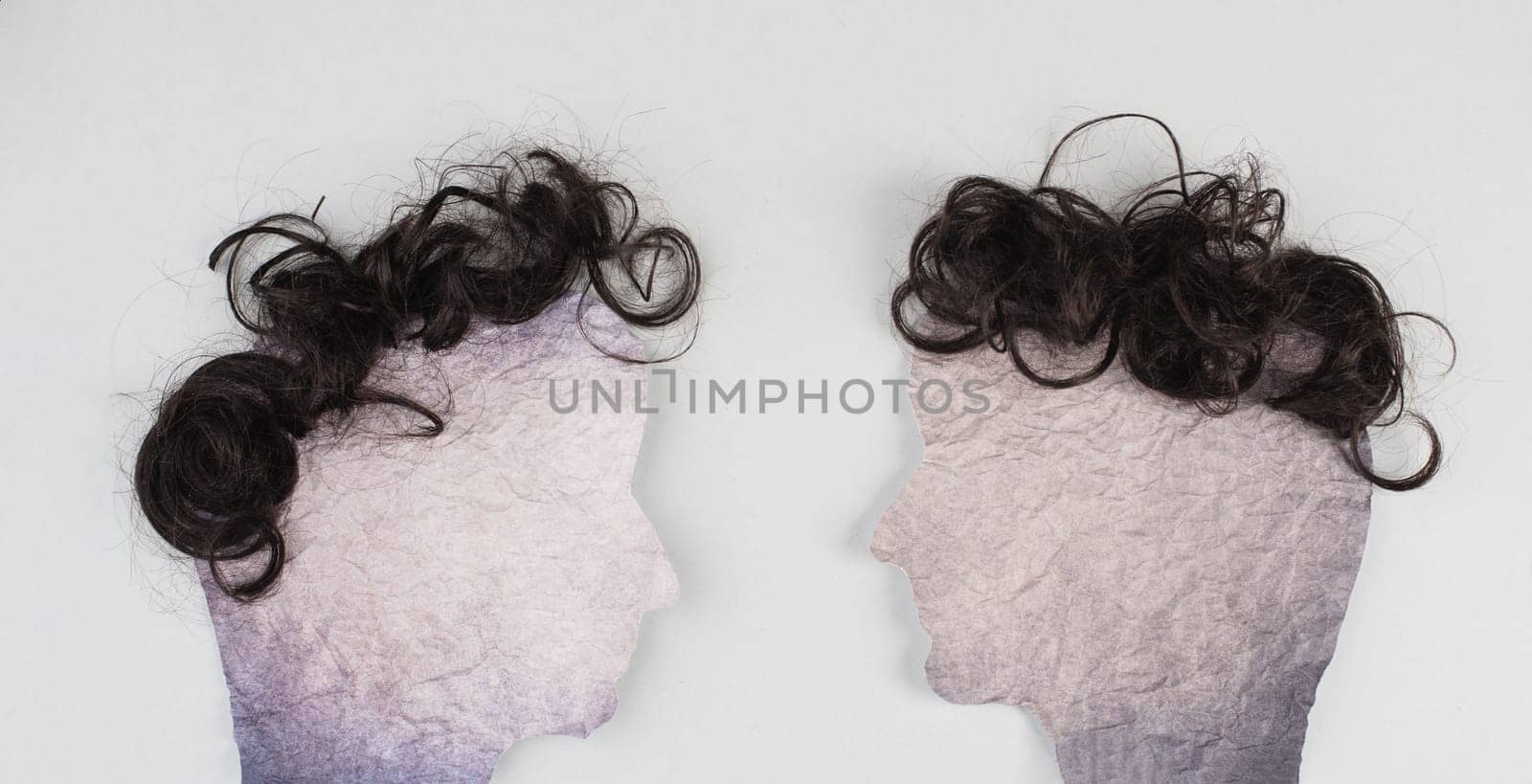 Silhouette of two faces with hair looking to each other, communication, having an opinion and discussion, free speech, people talking
