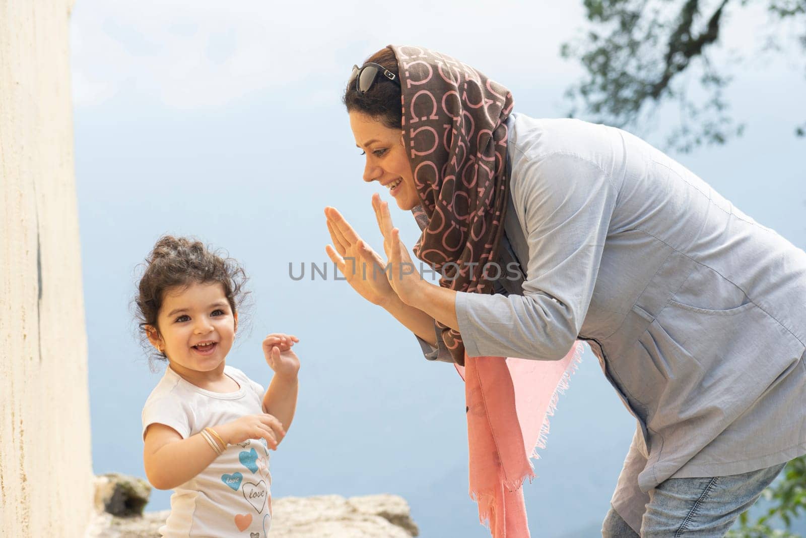 Young Muslim woman playing with her girl enjoying in the misty -fogy weather
