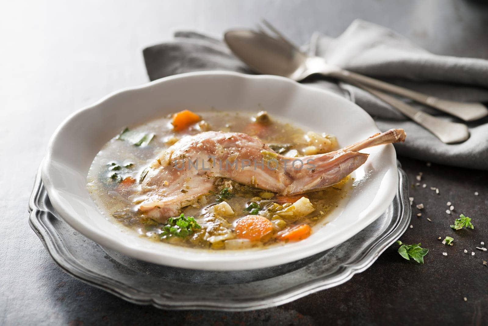 Serving healthy stew with rabbit meat and vegetables on grey background