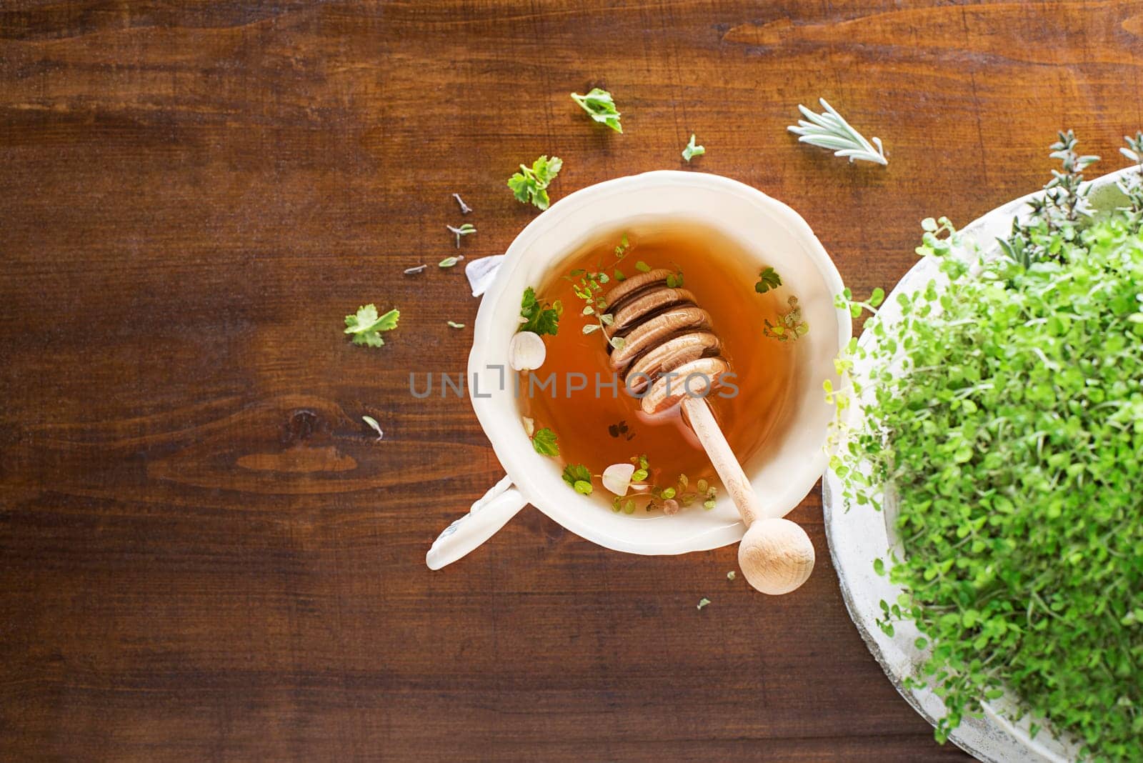 Tea Cup of fresh herbal leaves with honey on wooden background, top view, place for text. Healthy concept