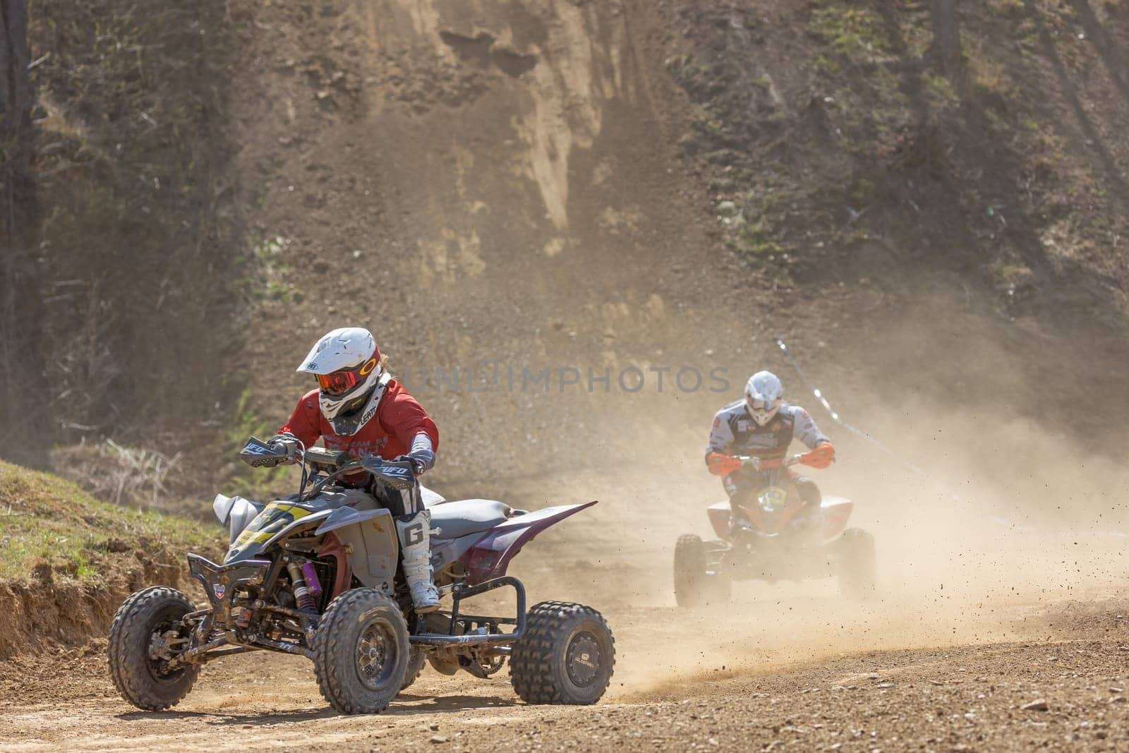 MOHELNICE,  CZECH REPUBLIC - APRIL 16, 2022: Two riders on a quad bike in the dust in International Championship of Czech Republic in Sidecarcross, category Quad on April 16, 2022 in Mohelnice.