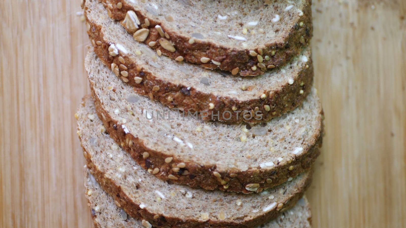 Slicing Whole Grain Bread On Wooden Table.