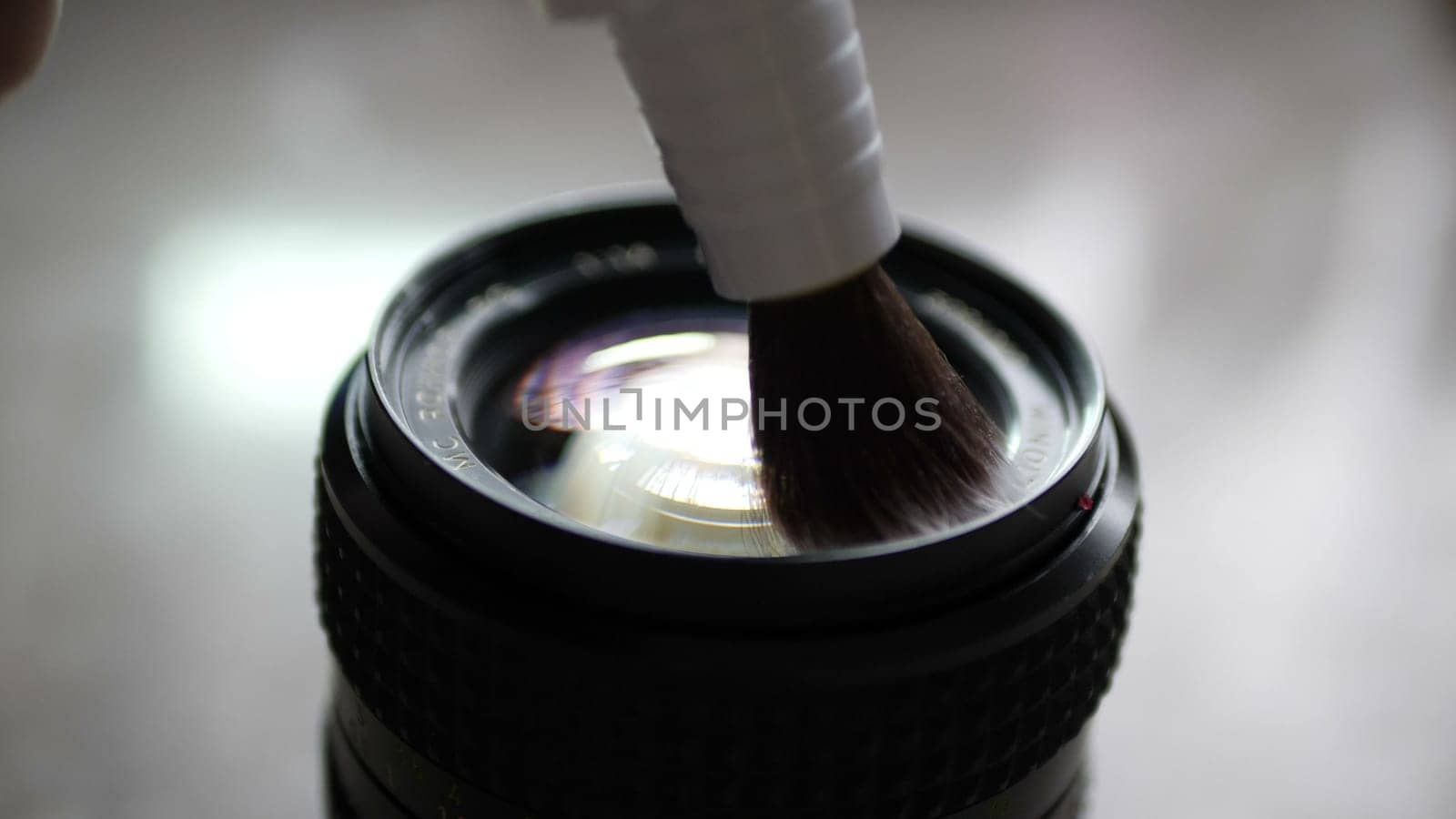 Cleaning camera lens with lens pen brush
