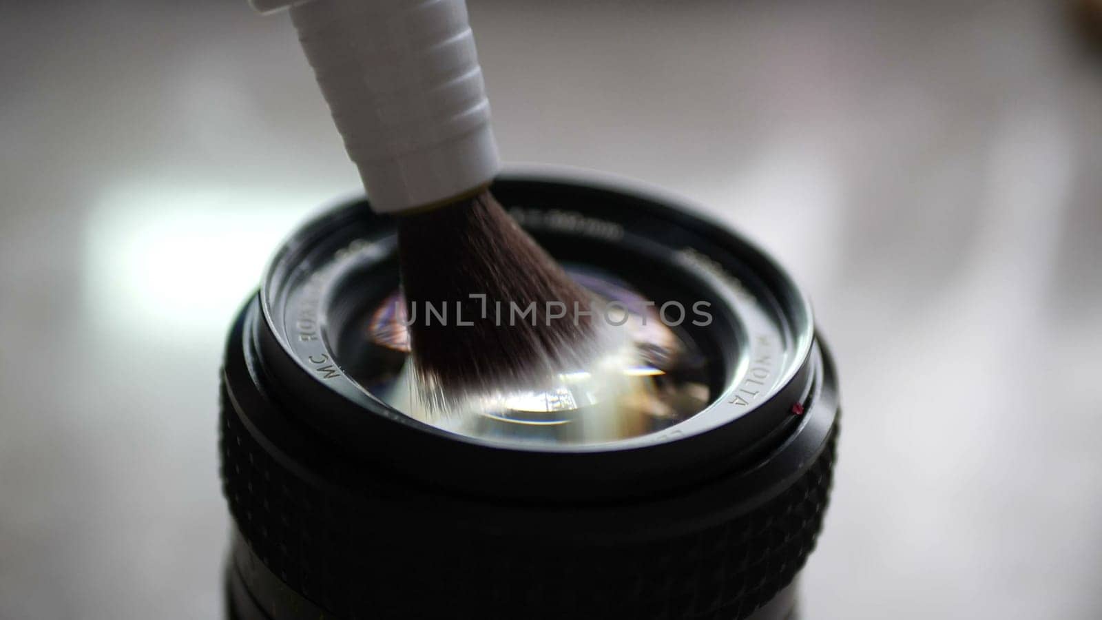 Cleaning camera lens with lens pen brush