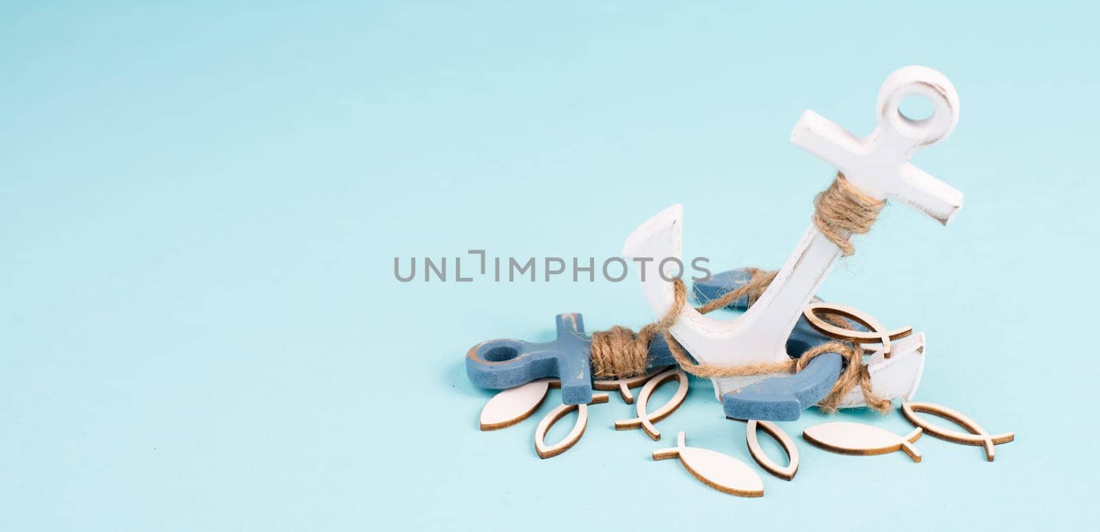White anchor and fish on a blue background, maritime sea life, sailing trip, summer vacation, tourism concept, harbor