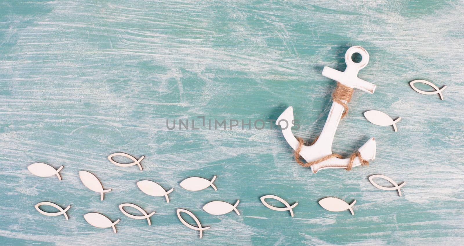 White anchor and fish on a blue background, maritime sea life, sailing trip, summer vacation, tourism concept, harbor