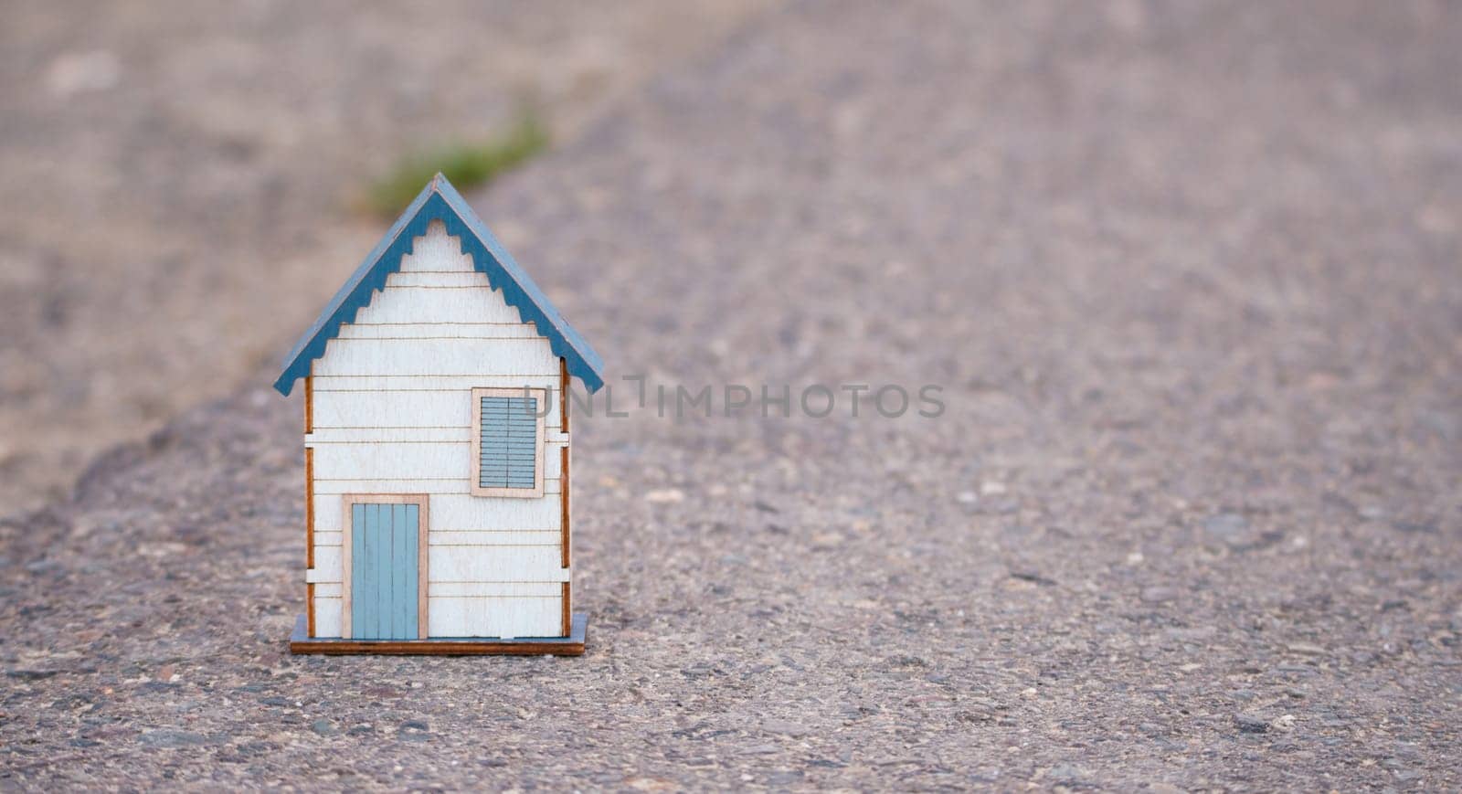 Small house standing on a road, real estate concept, renting or buying a home, travel and vacation symbol