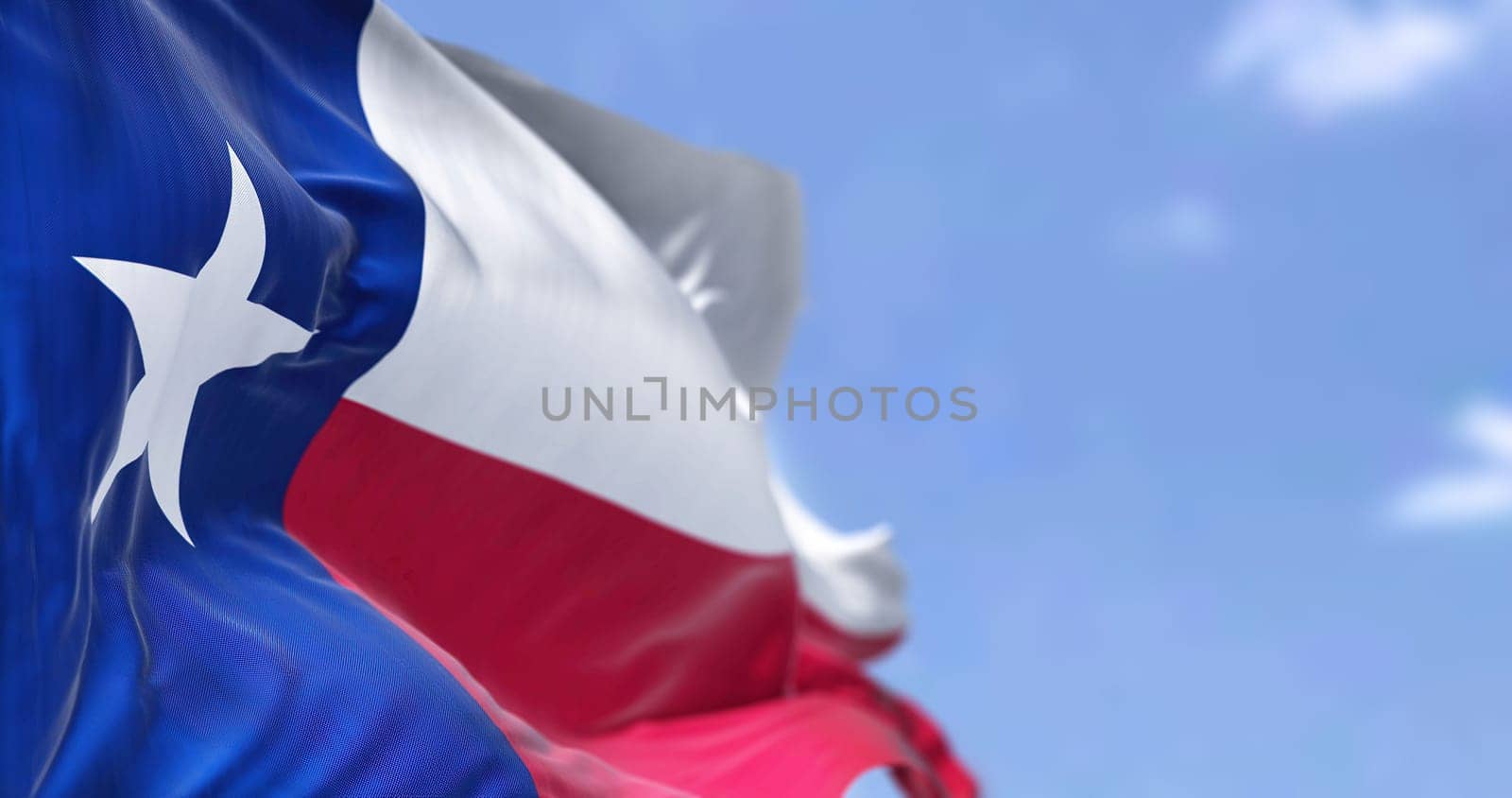 The US state flag of Texas waving in the wind. Texas is a state in the South Central region of the United States. Democracy and independence.
