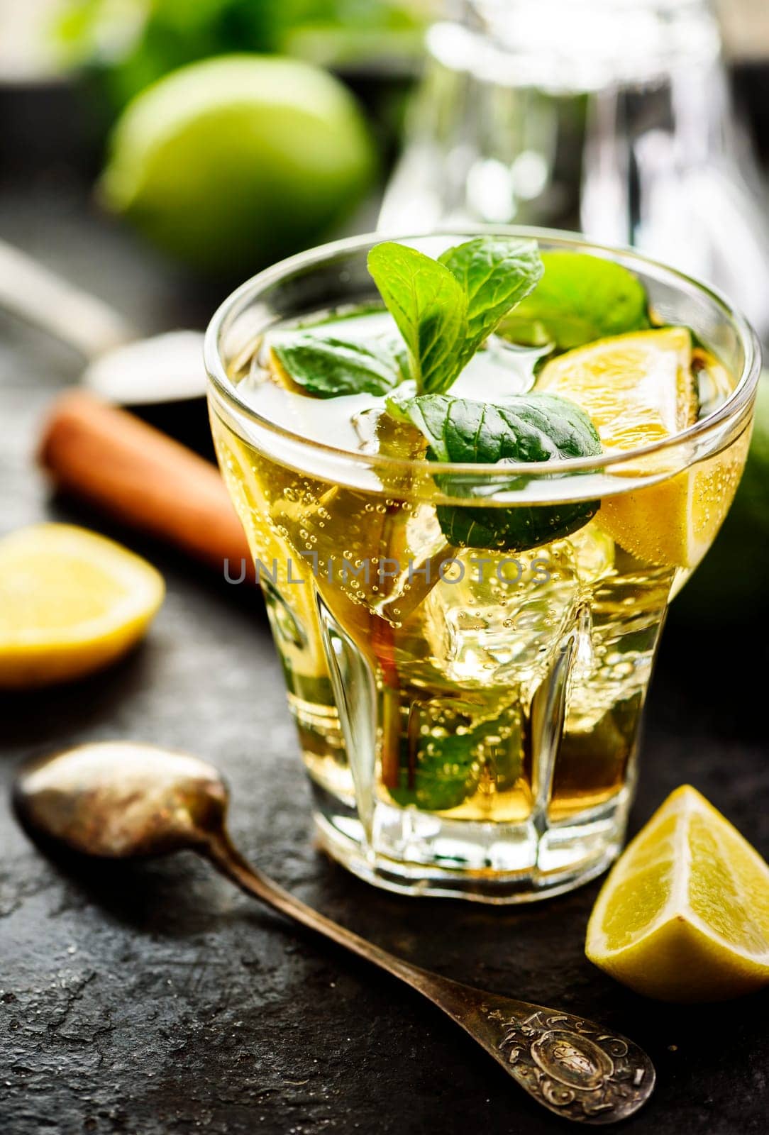Mojito cocktail and ingredients on dark table