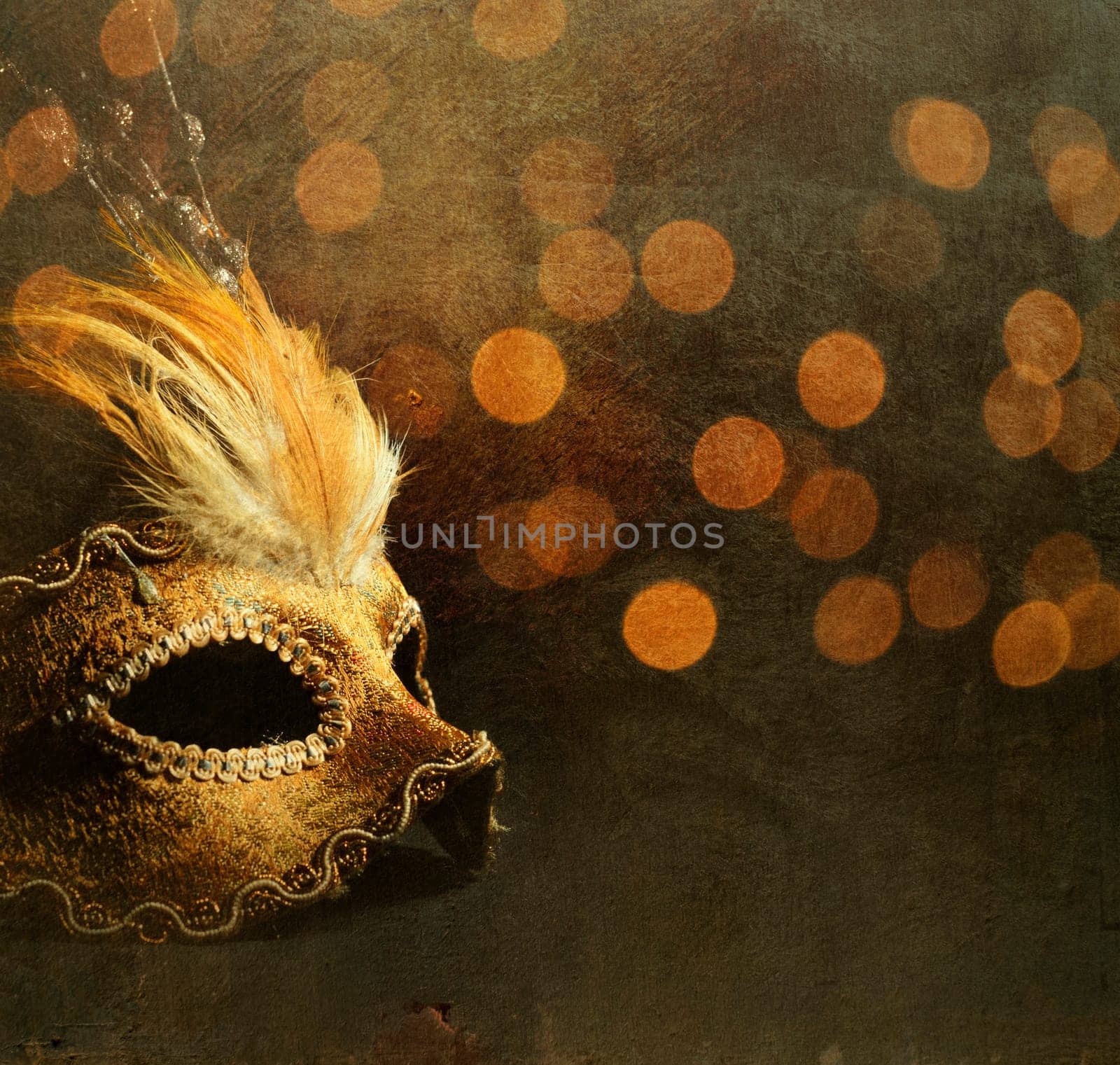 Golden venetian mask over shiny bokeh background with golden texture