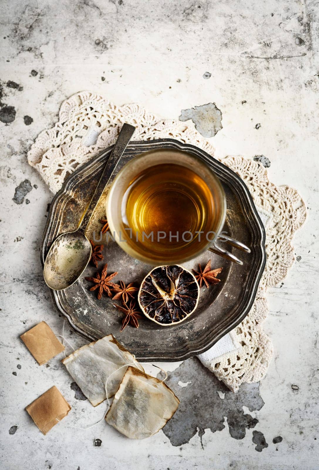 Cup of tea with anise seed on silver plate.
