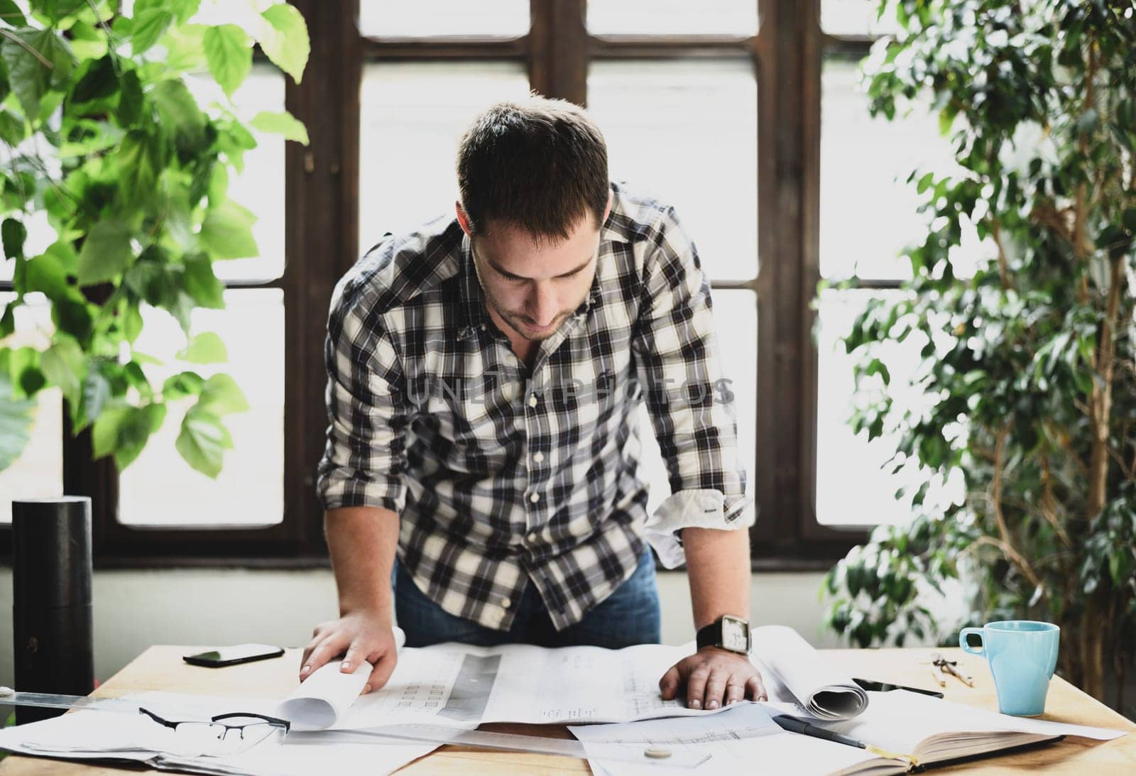 Young man working on architectural project. Modern office concept