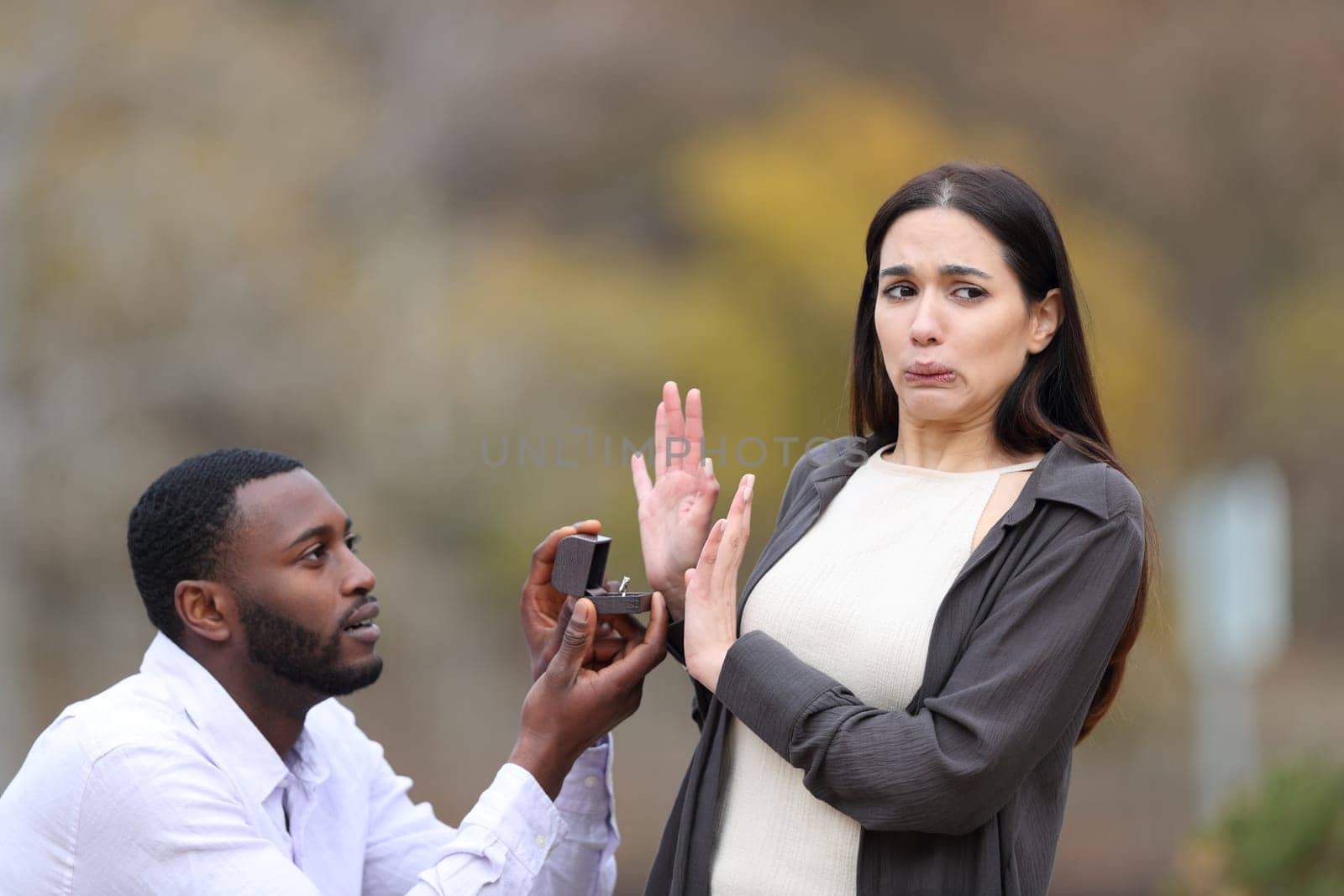 Man proposing marriage and scared woman rejecting